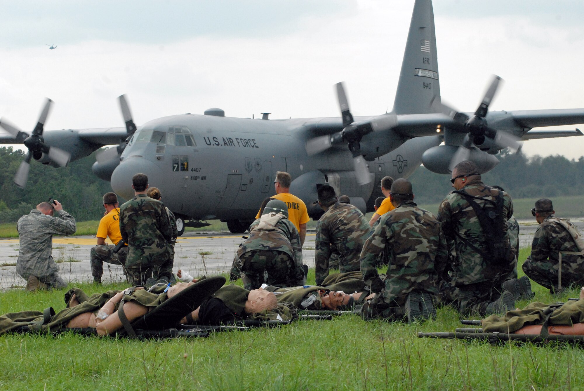 Airmen from the 60th Medical Group at Travis Air Force Base, Calif., and instructors from the 43rd Aeromedical Evacuation Squadron at Pope Air Force Base, N.C., prepare to load litters on an approaching C-130H during mobile aeromedical staging facility training at Fort Bragg's Camp Mackall, N.C., July 10. (U.S. Air Force photo/2nd Lt. Chris Hoyler)