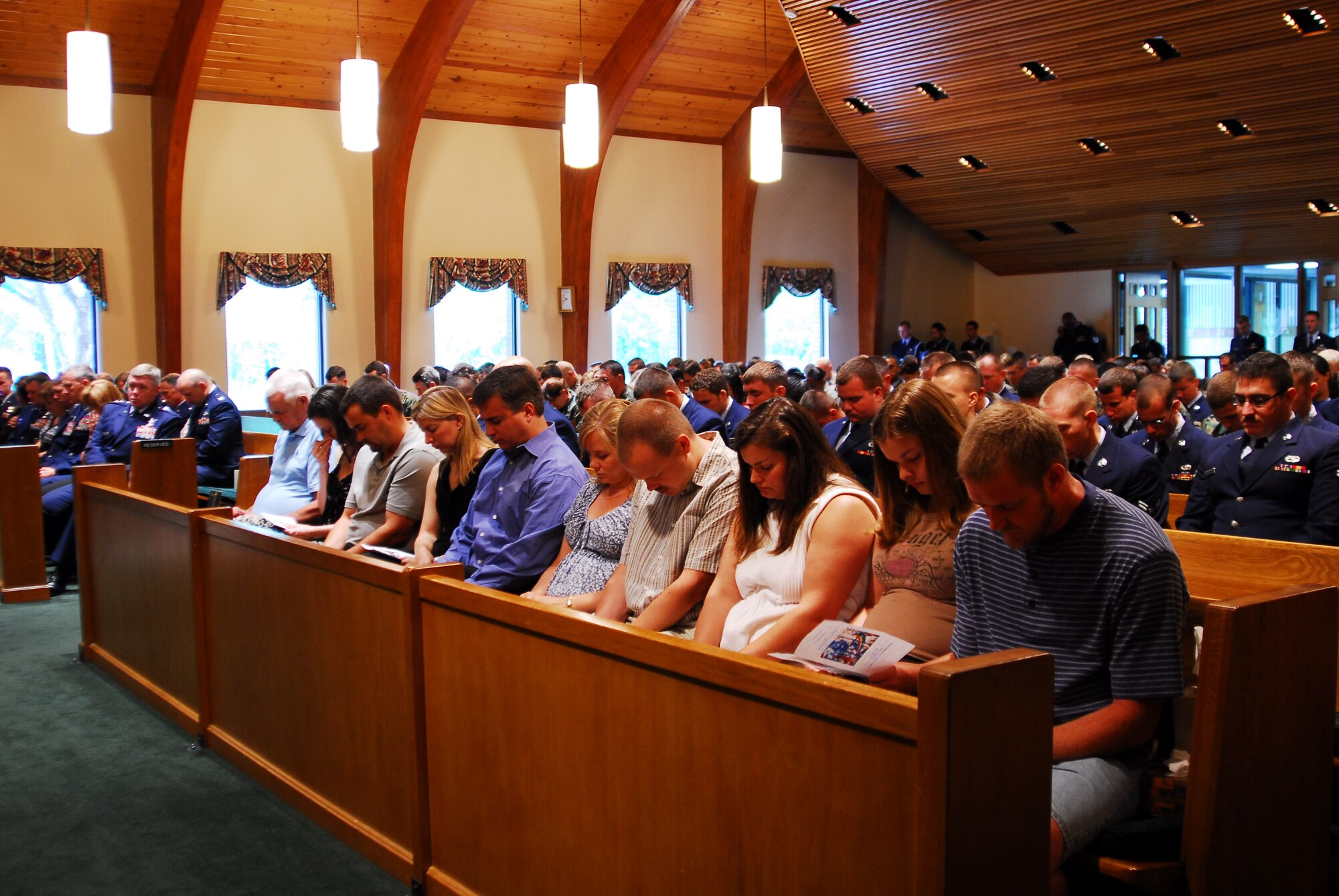 Family members, friends and co-workers pray during the memorial service for Staff Sgt. James Willis at the Hurlburt Field Chapel July 29. Sergeant Willis, who was assigned to the 4th Aircraft Maintenance Unit, died July 19 after being struck by lightning. (U.S. Air Force photo/Senior Airman Sheila deVera)