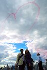 FARNBOROUGH, England -- Nitan Vadher and Seema Chudasama stand below the heart created by the Royal Air Force Aerobatic Team, the Red Arrows, just after they were engaged to be married. Mr. Vadher proposed to Ms. Chudasama on the flight deck of a C-130J aircraft July 20, 2008, during the Farnborough Air Show in England. (U.S. Air Force photo/Maj. Chad E. Gibson)