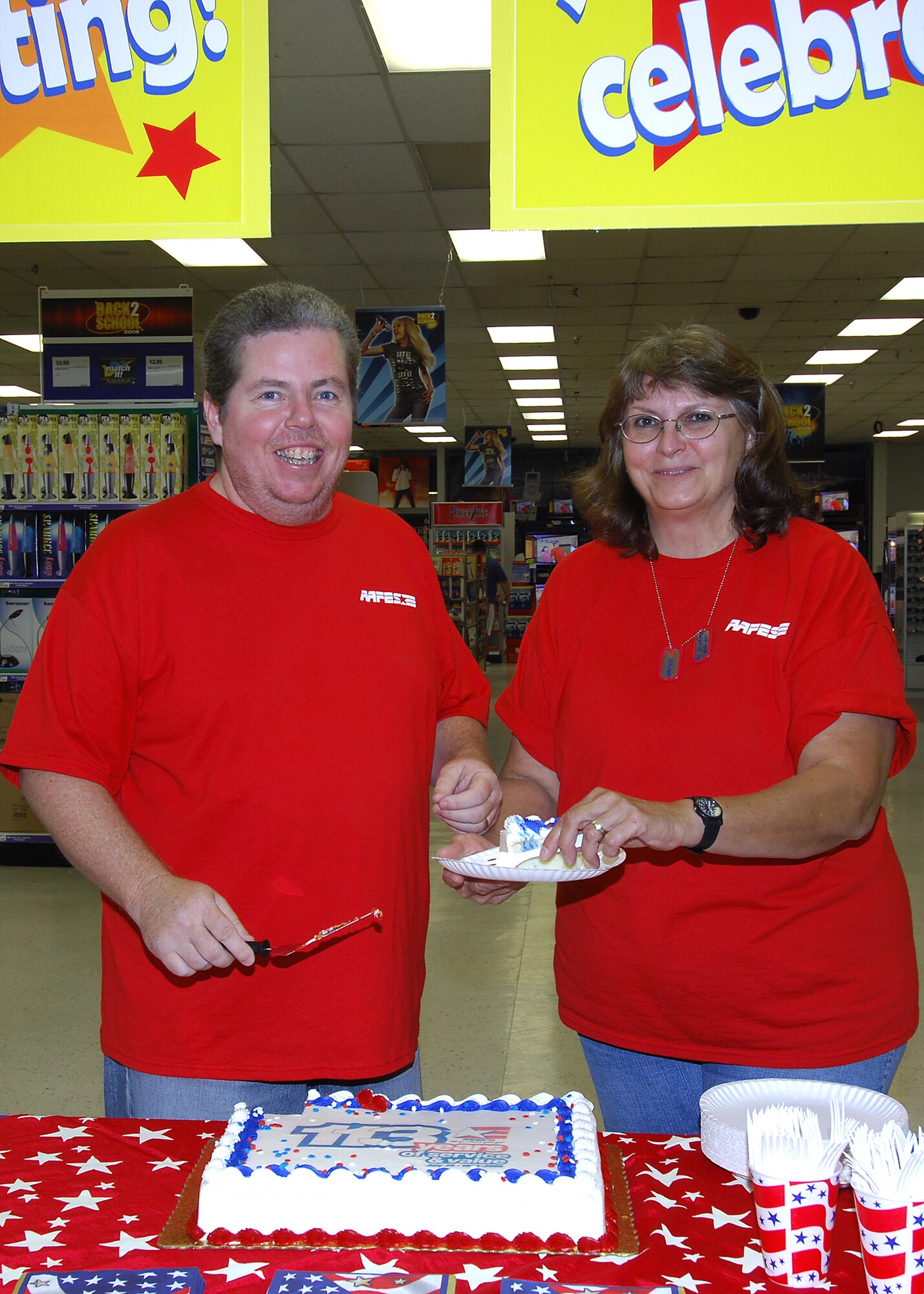 MINOT AIR FORCE BASE, N.D. -- Christine and Tom Healy, both employees of Minot AFB Army & Air Force Exchange Service, cut a cake for customers during a welcome back and birthday celebration here July 25. The Healys, along with two other Minot AFB AAFES employees, recently returned from a year-long deployment to Iraq in time to celebrate AAFES’ 113th birthday alongside other Minot AFB employees and customers. (U.S. Air Force photo by Senior Airman Kelly Timney)