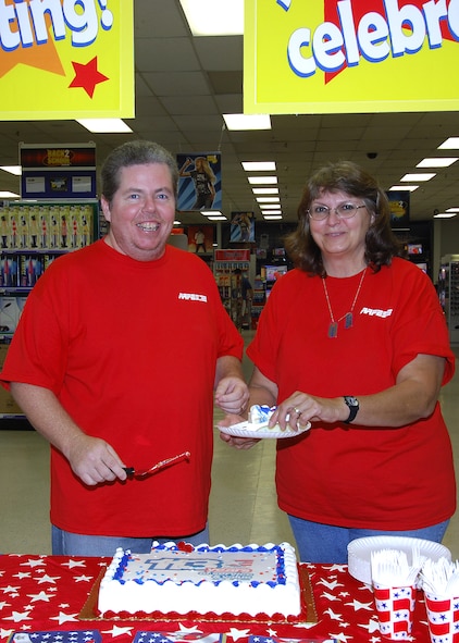 MINOT AIR FORCE BASE, N.D. -- Christine and Tom Healy, both employees of Minot AFB Army & Air Force Exchange Service, cut a cake for customers during a welcome back and birthday celebration here July 25. The Healys, along with two other Minot AFB AAFES employees, recently returned from a year-long deployment to Iraq in time to celebrate AAFES’ 113th birthday alongside other Minot AFB employees and customers. (U.S. Air Force photo by Senior Airman Kelly Timney)