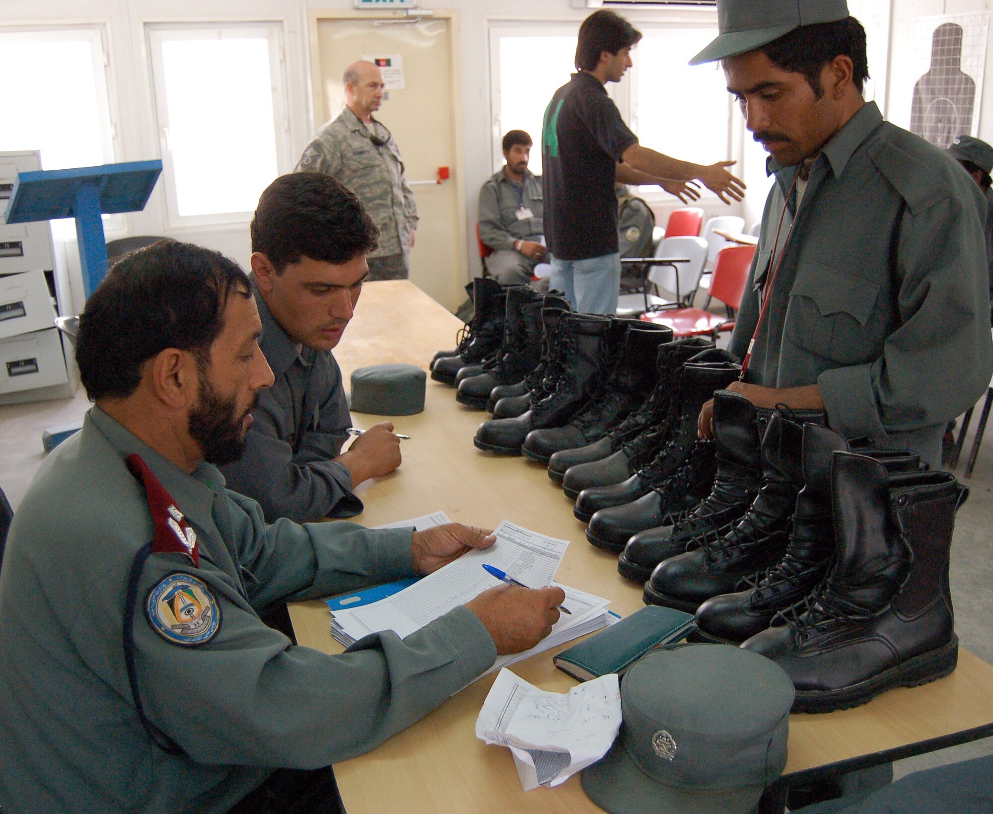Afghan National Police assigned to the Regional Training Center in Konduz, Afghanistan, record boot sizes during equipment issue for ANP students July 20. More than 200 police officers were processed for Focused District Development training, a program to create a professional and well-trained police force, district by district. (U.S. Air Force photo/Staff Sgt. Beth Del Vecchio)
