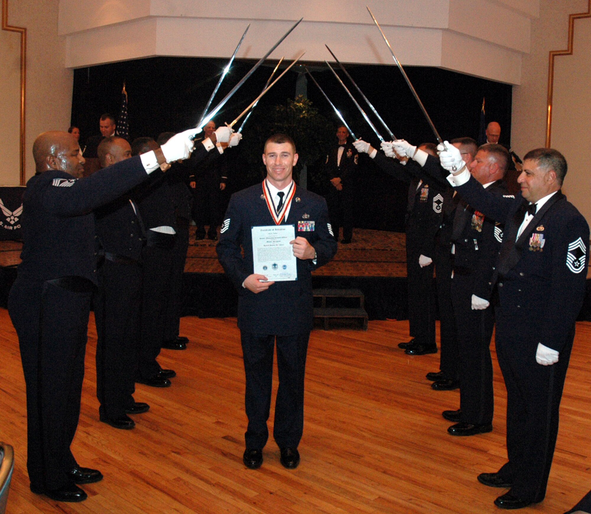Tech. Sgt. Kelly Tabor passes under the saber cordon during the 2008 McGuire Senior NCO Induction Ceremony July 25 at the McGuire Air Force Base, N.J., Club.  More than 40 technical sergeants were recognized during the ceremony for being selected for master sergeant and their eventual inclusion into the Air Force senior NCO corps.  Sergeant Tabor is from the U.S. Air Force Expeditionary Center's Expeditionary Operations School and its 421st Combat Training Squadron on Fort Dix, N.J.  (U.S. Air Force Photo/Tech. Sgt. Scott T. Sturkol)