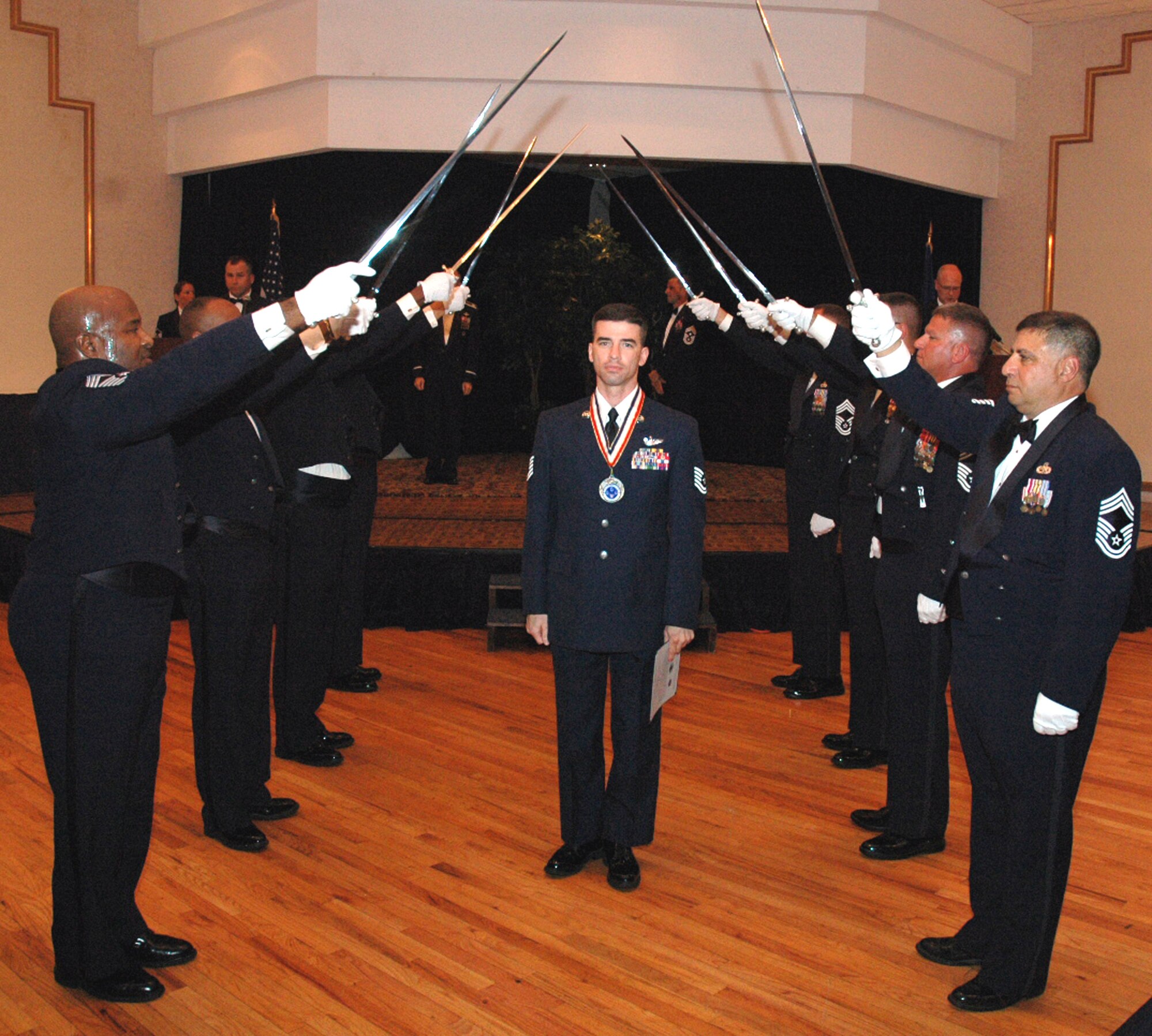 Tech. Sgt. C. Chris Sherman passes under the saber cordon during the 2008 McGuire Senior NCO Induction Ceremony July 25 at the McGuire Air Force Base, N.J., Club.  More than 40 technical sergeants were recognized during the ceremony for being selected for master sergeant and their eventual inclusion into the Air Force senior NCO corps.  Sergeant Sherman is from the U.S. Air Force Expeditionary Center's Mobility Operations School on Fort Dix, N.J.  (U.S. Air Force Photo/Tech. Sgt. Scott T. Sturkol)