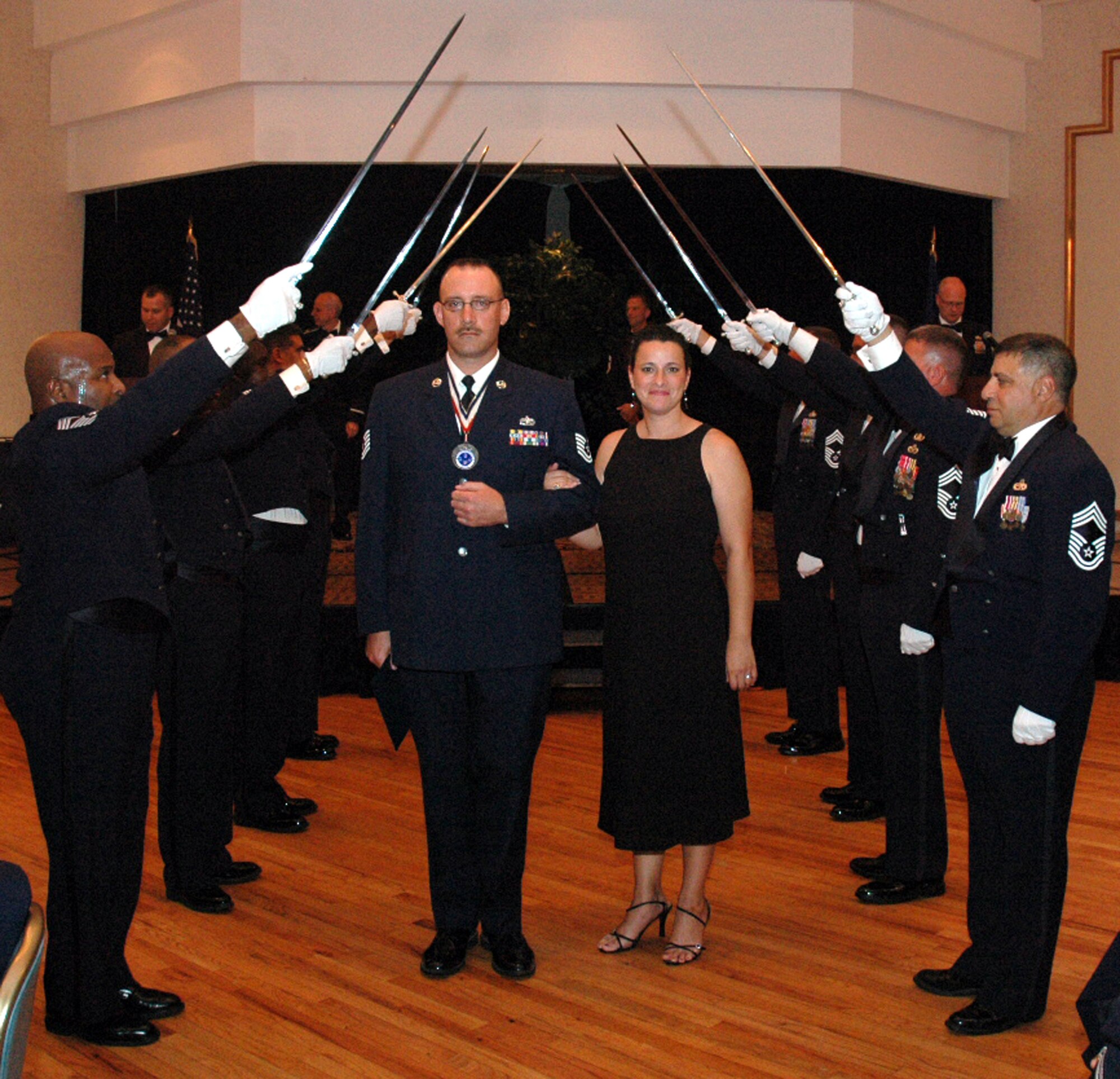 Tech. Sgt. Duane Rowles and his wife Elizabeth pass under the saber cordon during the 2008 McGuire Senior NCO Induction Ceremony July 25 at the McGuire Air Force Base, N.J., Club.  More than 40 technical sergeants were recognized during the ceremony for being selected for master sergeant and their eventual inclusion into the Air Force senior NCO corps.  Sergeant Rowles is from the U.S. Air Force Expeditionary Center's Mobility Operations School on Fort Dix, N.J.  (U.S. Air Force Photo/Tech. Sgt. Scott T. Sturkol)