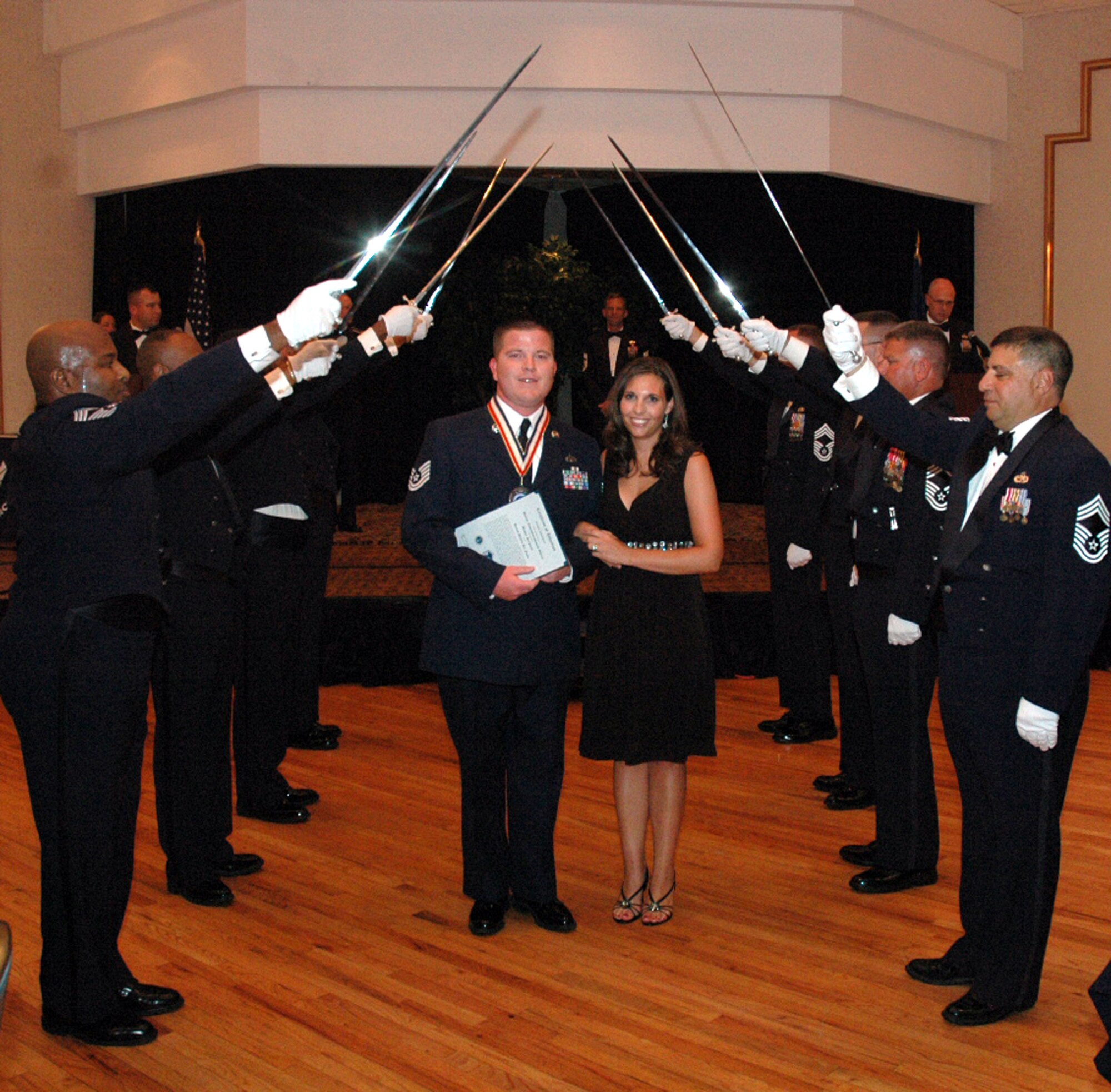 Tech. Sgt. Joseph Neubauer and his wife Michelle pass under the saber cordon during the 2008 McGuire Senior NCO Induction Ceremony July 25 at the McGuire Air Force Base, N.J., Club.  More than 40 technical sergeants were recognized during the ceremony for being selected for master sergeant and their eventual inclusion into the Air Force senior NCO corps.  Sergeant Neubauer is from the U.S. Air Force Expeditionary Center's Mobility Operations School on Fort Dix, N.J.  (U.S. Air Force Photo/Tech. Sgt. Scott T. Sturkol)