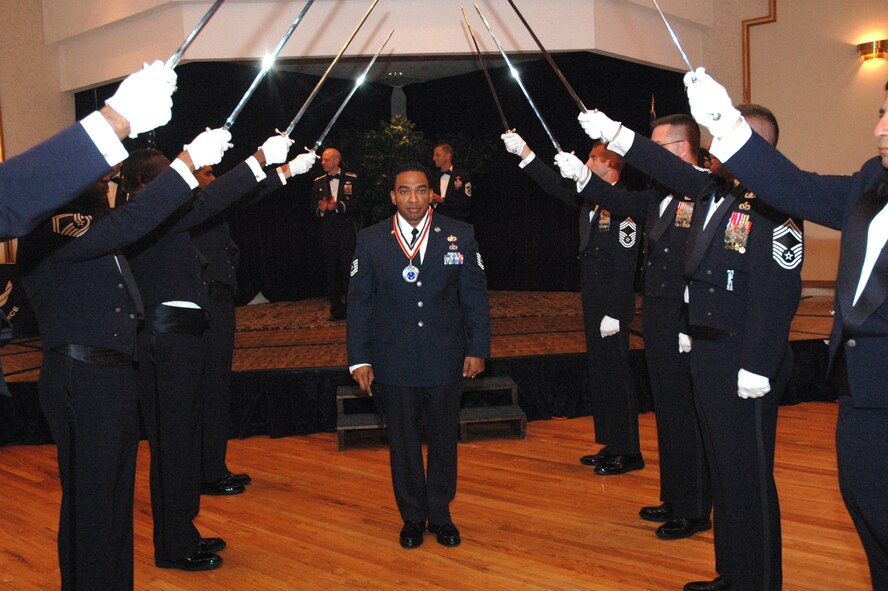 Tech. Sgt. Ray Anderson passes under the saber cordon during the 2008 McGuire Senior NCO Induction Ceremony July 25 at the McGuire Air Force Base, N.J., Club.  More than 40 technical sergeants were recognized during the ceremony for being selected for master sergeant and their eventual inclusion into the Air Force senior NCO corps.  Sergeant Anderson is from the 305th Air Mobility Wing military equal opportunity office.  (U.S. Air Force Photo/Tech. Sgt. Scott T. Sturkol)