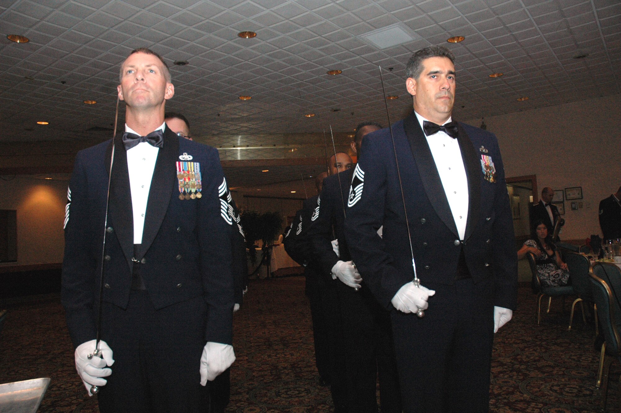 A group of eight chief master sergeants from McGuire Air Force Base, N.J., make up the "saber cordon" for the 2008 McGuire Senior NCO Induction Ceremony July 25 at the McGuire Club.  More than 40 technical sergeants were recognized during the ceremony for being selected for master sergeant and their eventual inclusion into the Air Force senior NCO corps.  The saber cordon raised their sabers like the "rooftop" of an Air Force master sergeant stripe.  (U.S. Air Force Photo/Tech. Sgt. Scott T. Sturkol) 