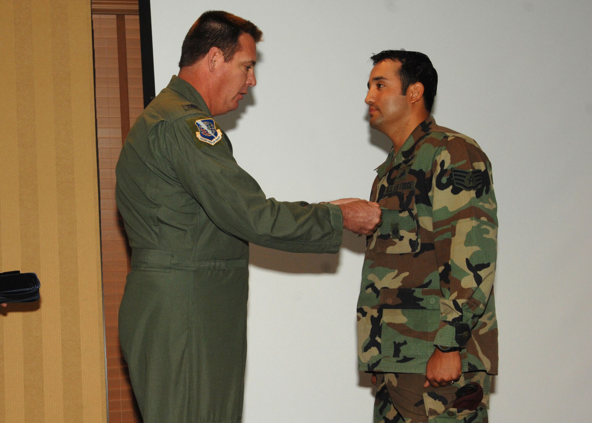 Col. Lee DePalo, 563rd Rescue Group commander, presents the Bronze Star Medal to Staff Sgt. Jose Cervantes during a commander’s call at the Officers’ Club here July 25.  Sergeant Cervantes was awarded the Bronze Star for his meritorious service as a pararescue team member while deployed to Afghanistan from May 5, 2006 to May 7, 2007.  During this period, while exposed to extreme danger from hostile machine gun fire and rocket attacks, Sergeant Cervantes courageously executed recovery operations for a crashed CH-47 helicopter.  (U.S. Air Force photo by Senior Airman Alesia Goosic)