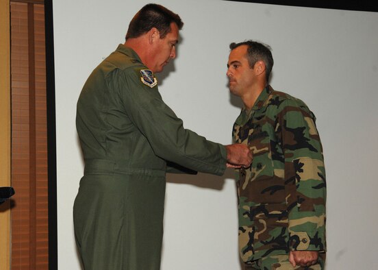 Col. Lee DePalo, 563rd Rescue Group commander, presents the Bronze Star Medal to Capt. Patrick O'Rourke during a commander's call at the Officers' Club here July 25. Captain O'Rourke was awarded the Bronze Star for his meritorious service as a combat rescue officer while deployed to Afghanistan from May 5, 2006 to May 7, 2007. During this period, while exposed to extreme danger from hostile machine gun fire and rocket attacks, Captain O'Rourke courageously led his team of four pararescuemen during recovery operations of a crashed CH-47 helicopter. The 563rd RQS is part of the 23rd Wing at Moody Air Force Base, Ga.(U.S. Air Force photo by Senior Airman Alesia Goosic)