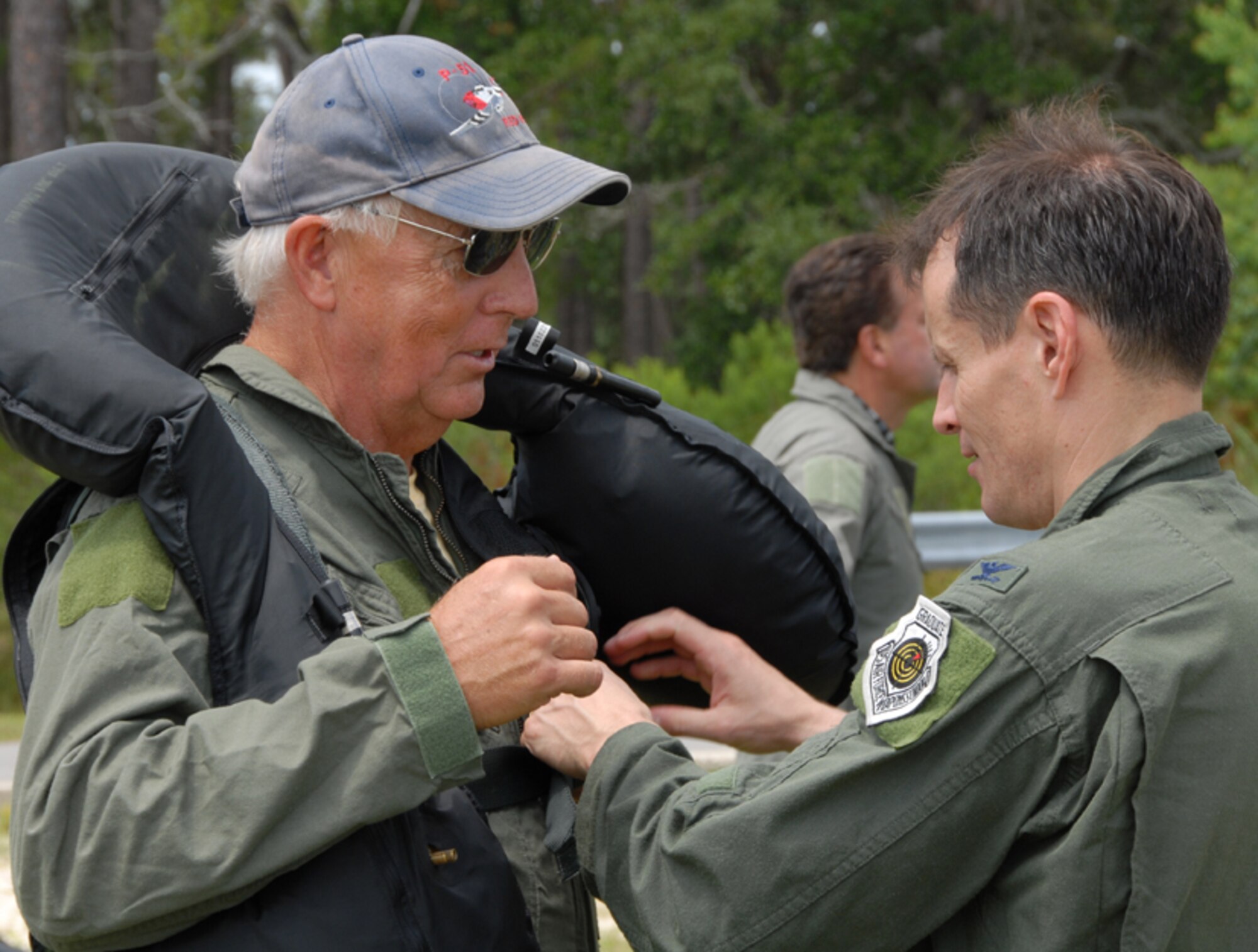 Col Steve DePalmer, 53d Wing commander, helps his honorary commander, Dr. Joe Carnley, during the water survival training event held July 25 at Eglin Air Force Base, Fla.  The event, hosted by the 33rd Fighter Wing, was a demonstration for both of the wings' honorary commander programs.The wings' honoraries participated in hands-on training with live flares, parachutes, life rafts and life support gear.  They also watched a simulated water rescue with a helicopter.  Photo by Staff Sgt. Samuel King Jr.