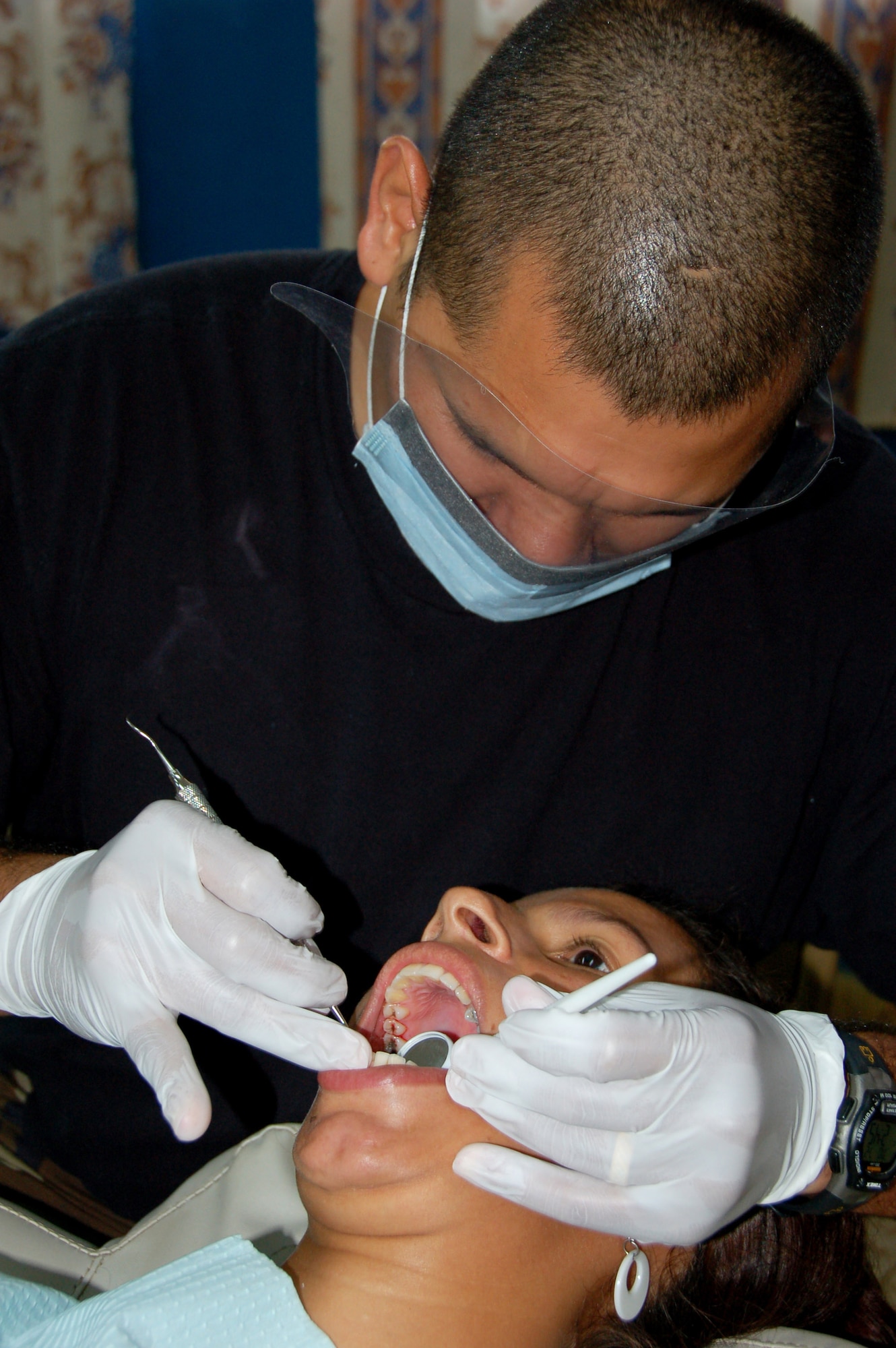 Staff Sgt. Juan Gutierrez, a bilingual dental technician from the 42nd Medical Group deployed to Medical Readiness Training Exercise Panama, cleans a patient’s teeth at a school in Pesé, Panama, Monday. (Air Force photo by Capt. Ben Sakrisson)