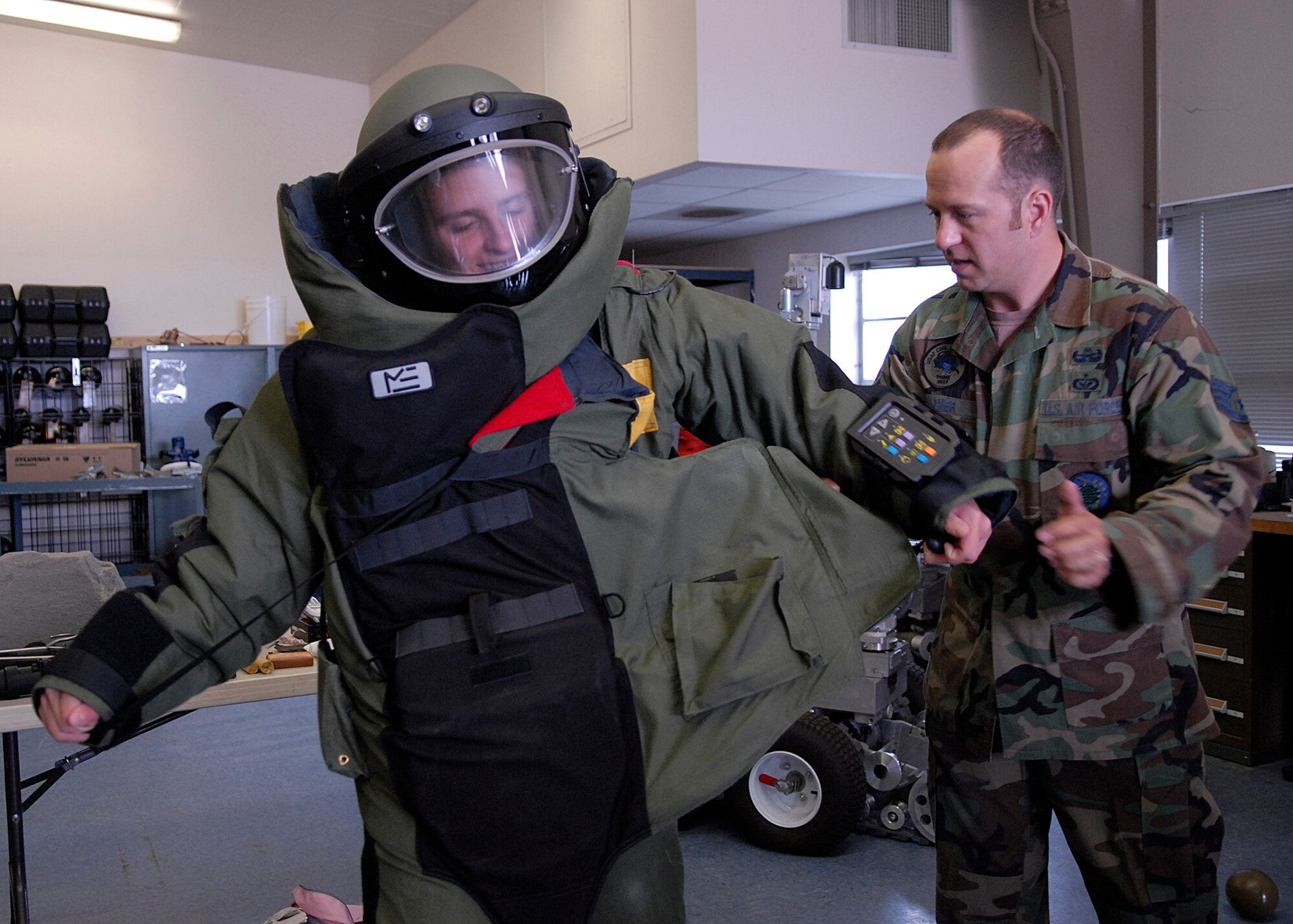 VANDENBERG AIR FORCE BASE, Calif. --  Staff Sgt. Jonathan Homer, a 30th Civil Engineer Squadron explosive ordnance disposal technician, teaches Cadet Senior Master Sgt. Jerry Jacobs, a Civil Air Patrol cadet, how to use the quick release for the EOD 9 bombsuit July 24 here. (U.S. Air Force photo/Airman 1st Class Andrew Satran)