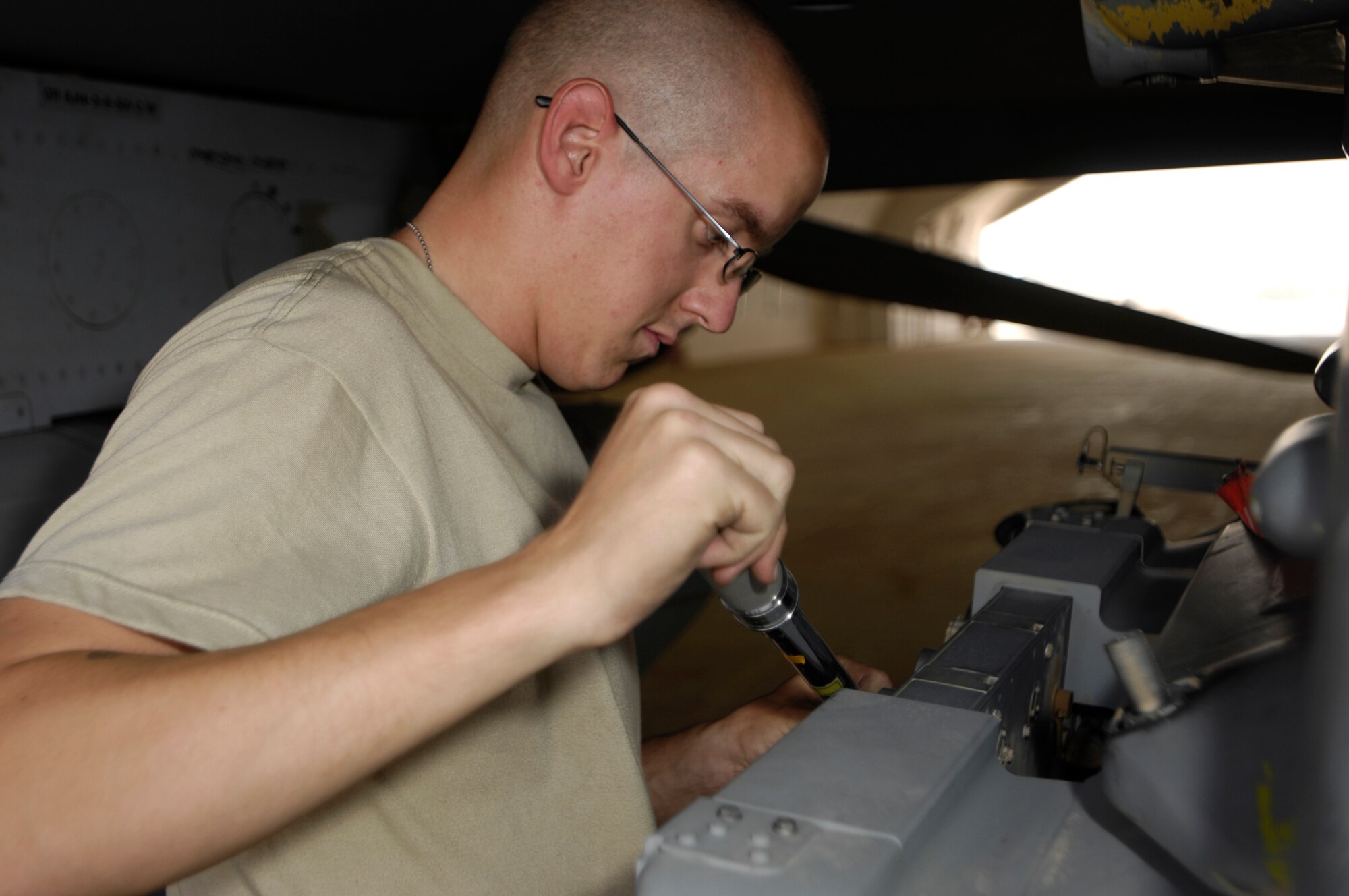 JOINT BASE BALAD, Iraq -- Senior Airman Benjamin Sylvester checks the torque on an F-16 Fighting Falcon's bomb release unit's explosive cartridge retainers during maintenance here July 28. Inspections like these ensure that the F-16's weapons systems are functioning properly. The bomb release unit communicates with the aircraft's computer to release the bomb. Airman Sylvester is a weapons load team crewmember with the 332nd Expeditionary Aircraft Maintenance Squadron and is deployed from Hill Air Force Base, Utah. (U.S. Air Force photo by Airman 1st Class Jason Epley)