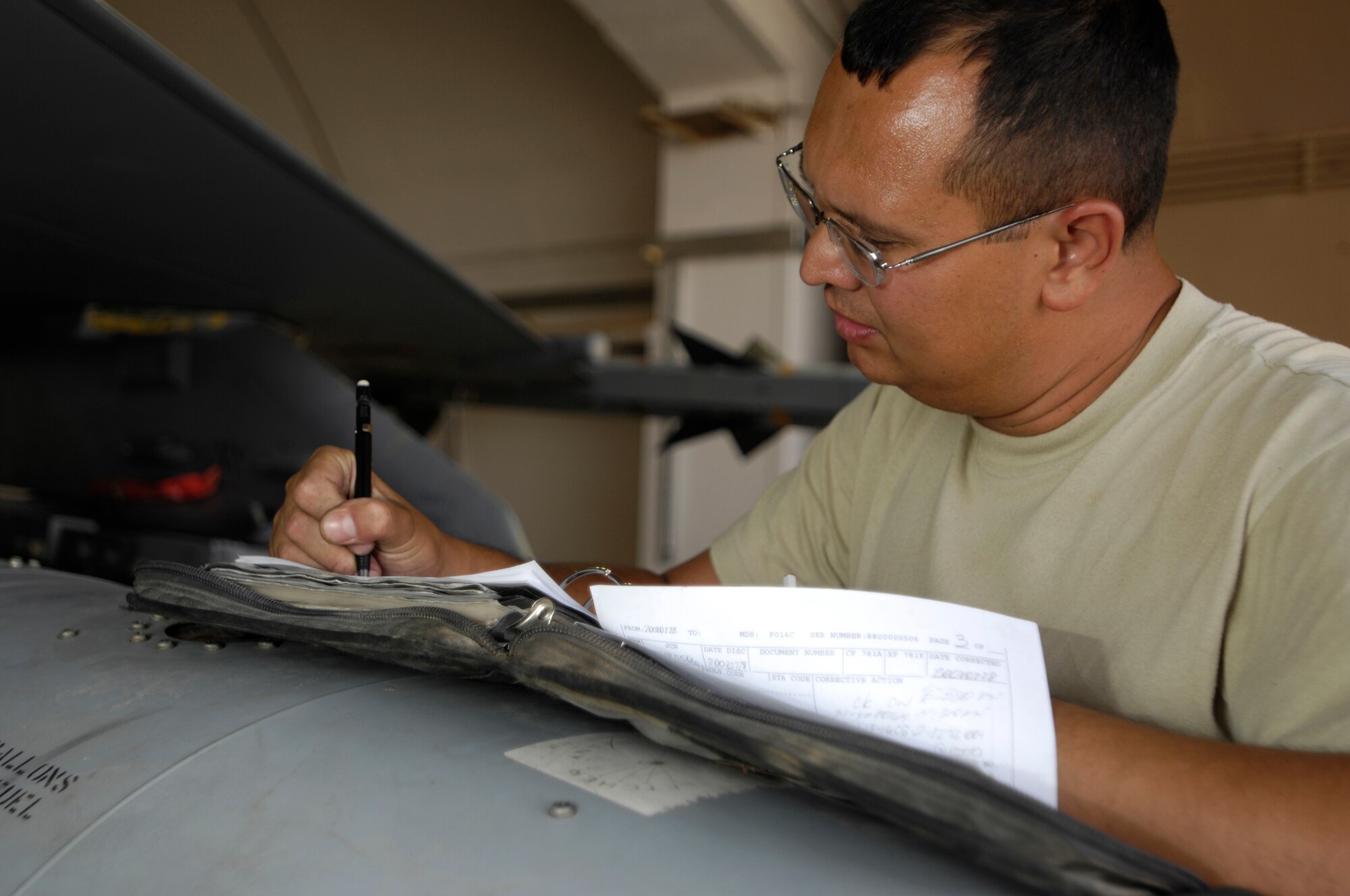 JOINT BASE BALAD, Iraq -- Staff. Sgt. Jeremy Boileau fills out a form after completing a missile interface check on an F-16 Fighting Falcon here July 28. Inspections like these ensure that the F-16's weapons systems are functioning properly. Sergeant Boileau is a weapons load team crew chief with the 332nd Expeditionary Aircraft Maintenance Squadron and is deployed from Hill Air Force Base, Utah. (U.S. Air Force photo by Airman 1st Class Jason Epley)