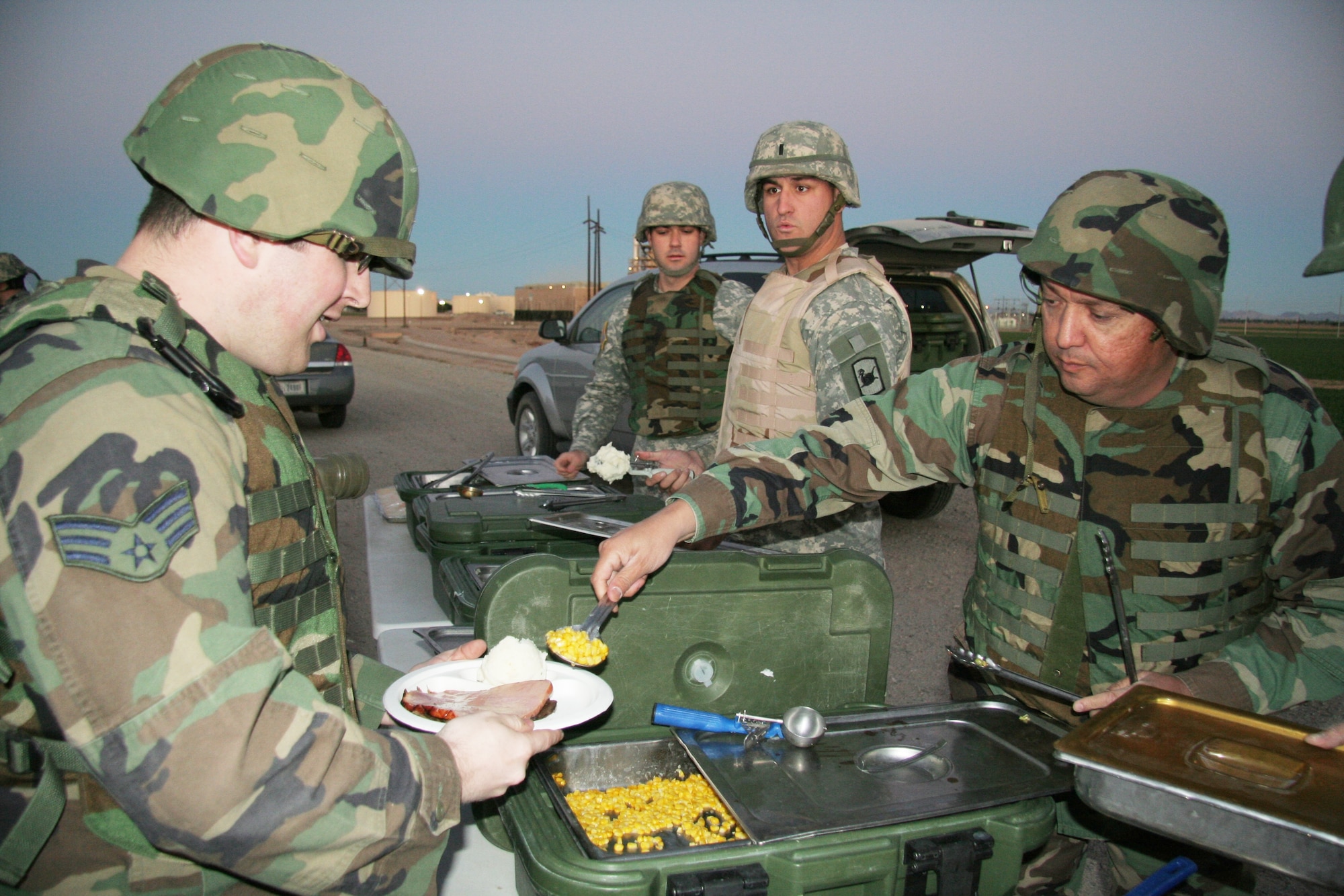 Chaplain (Maj.) Mike Martinez (right) serves a hot meal on Christmas Eve to an Airman assigned to an entrance identification team in Yuma, Ariz., as part of Operation Jump Start. (Army National Guard photo by Sgt.Ed Balaban)