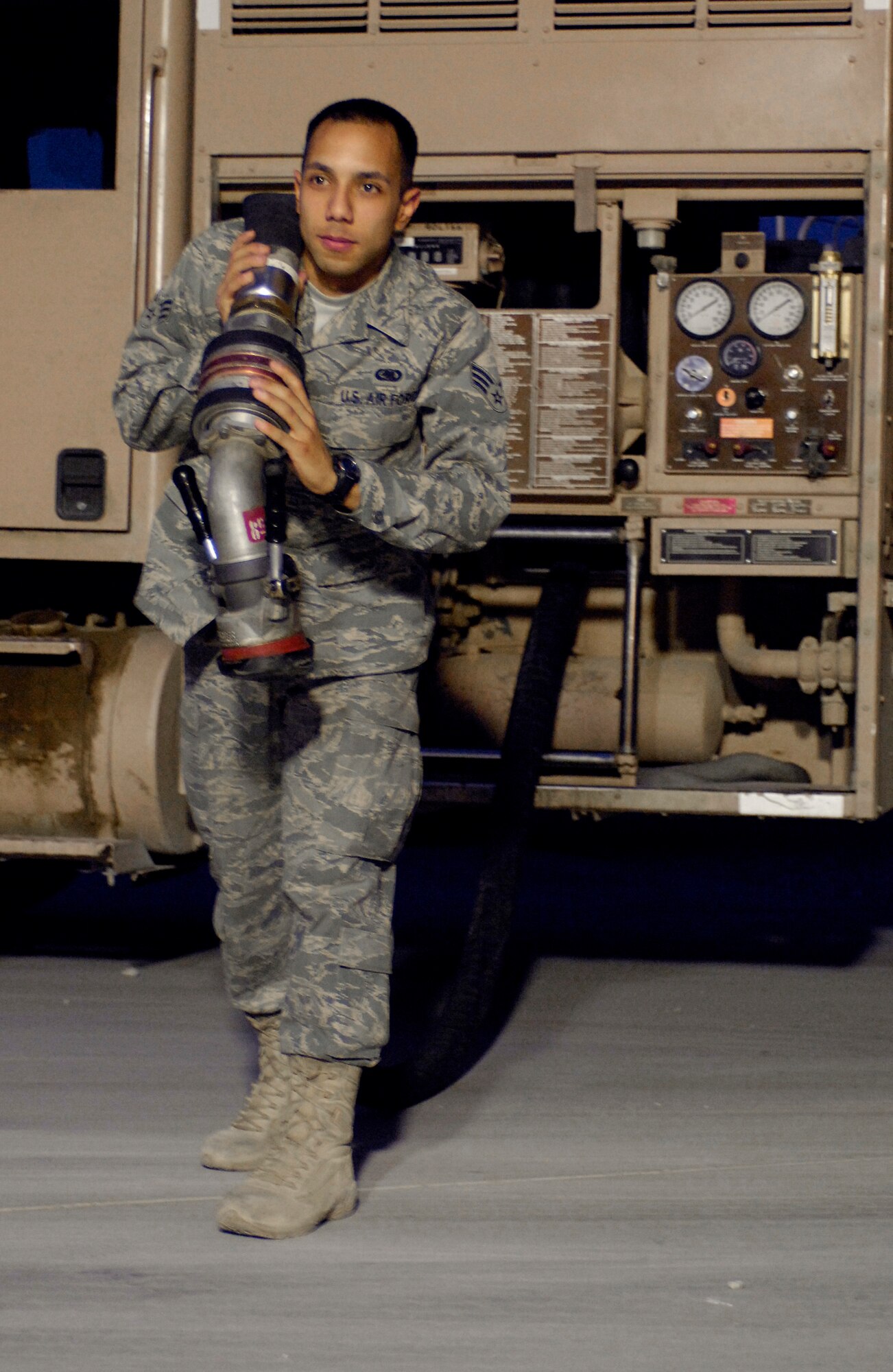 BAGRAM AIR FIELD, Afghanistan -- Senior Airman Ramon Negron, a fuels distribution operator assigned to the 455th Expeditionary Logistics Readiness Squadron, pulls a hose from a fuel truck while preparing to refuel an aircraft here July 27, 2008. Airman Negron, deployed from McChord Air Force Base, Wash., broke the Bagram fuel record by pumping one million gallons in 61 days. (U.S. Air Force photo by Staff Sgt. Rachel Martinez)