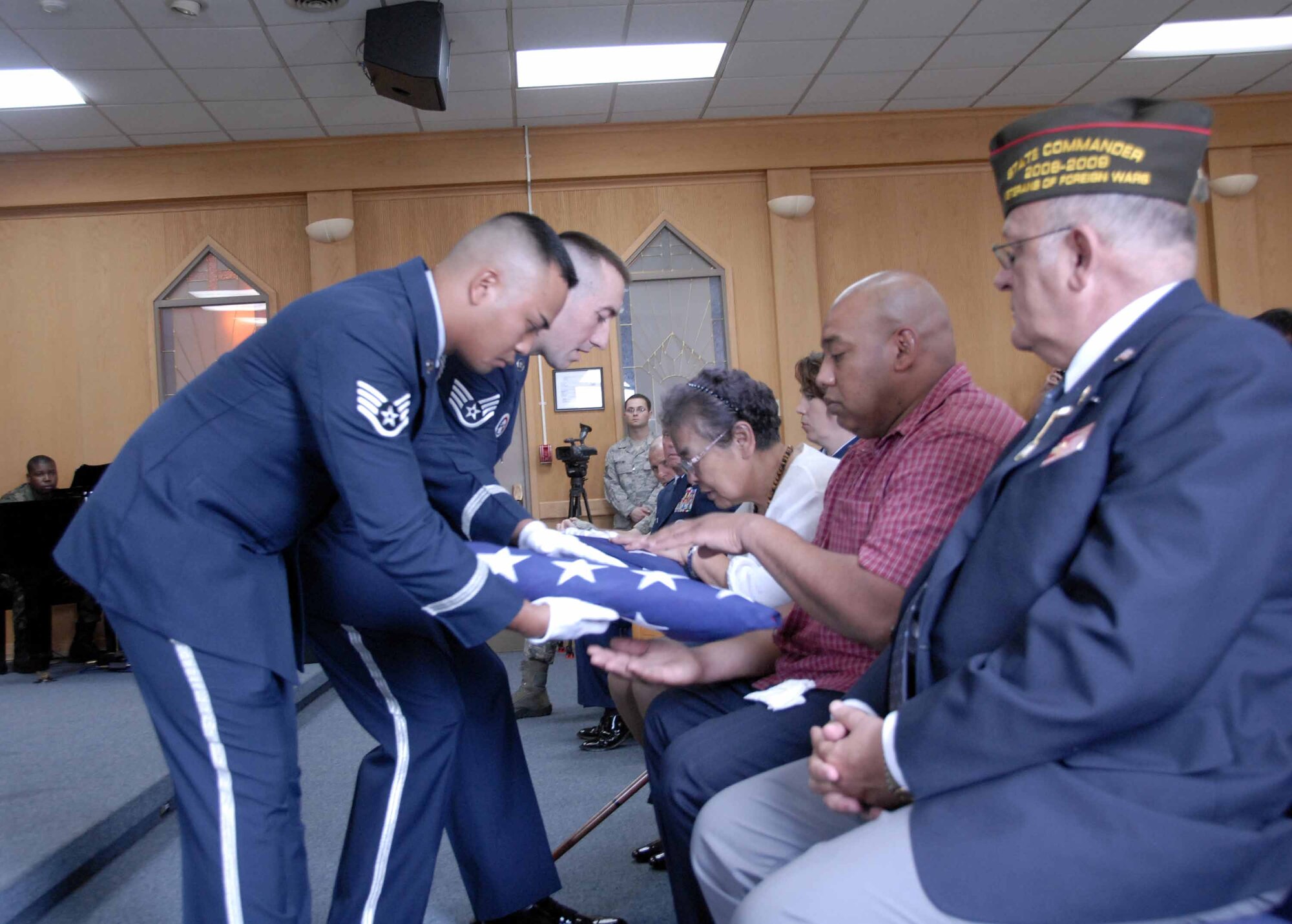OSAN AIR BASE, Republic of Korea -- Sok Kyun Price, (right) wife of the  late Master Sgt. (retired) James T. Price, and their son Steven, receive folded flags from members of the base honor guard during a memorial service held for Sergeant Price at the base chapel here July 29. Sergeant Price passed away July 20, succumbing to injuries suffered in an accidental fall several weeks ago. (U.S. Air Force photo/Staff Sgt. Lakisha Croley)