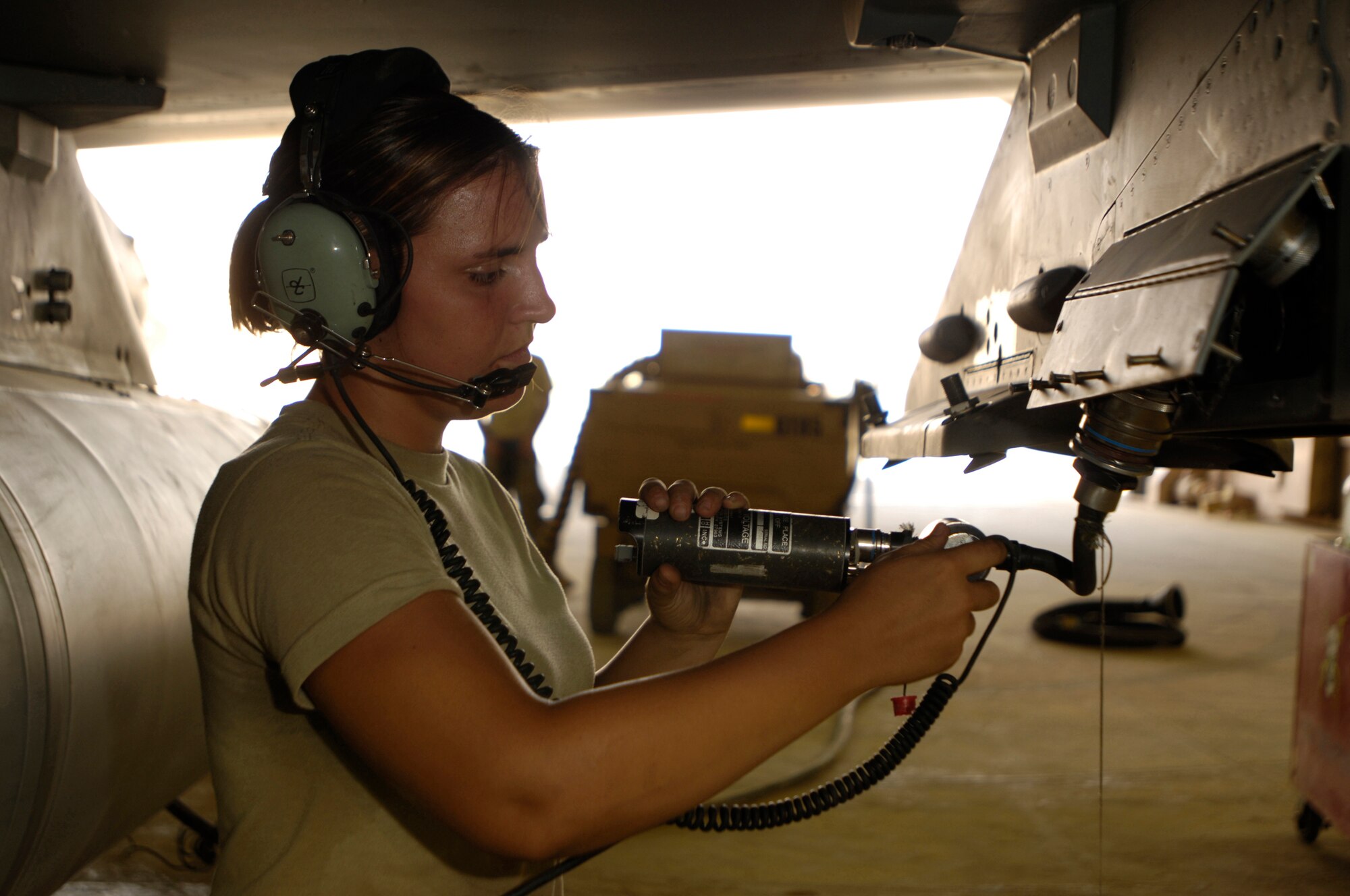 JOINT BASE BALAD, Iraq -- Senior Airman Kimberly Bickford performs a pre-load check on an F-16 Fighting Falcon here July 28 to ensure the cable that releases the bomb is operational. By communicating through a headset with another Airman inside the cockpit, Airman Bickford can troubleshoot any problems that may arise. Airman Bickford is an aircraft armament specialist with the 332nd Expeditionary Aircraft Maintenance Squadron and is deployed from Hill Air Force Base, Utah. (U.S. Air Force photo/Airman 1st Class Jason Epley)