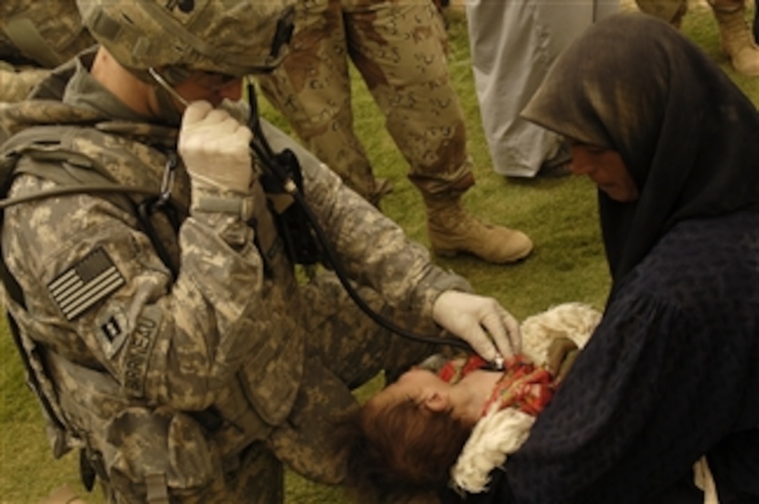 U.S. Army Capt. Damien Barrineau examines a child during a medical operation in Sayid Ghrib, Iraq, on July 27, 2008.  Barrineau is assigned to 2nd Battalion, 320th Field Artillery Regiment, 1st Brigade Combat Team, 101st Airborne Division.  
