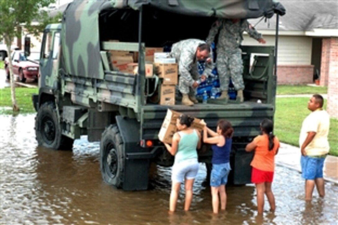 Texas National Guard soldiers distribute food, water and ice, July 25, 2008, from a tactical vehicle to residents of Raymondville, Texas, flooded by Hurricane Dolly. 