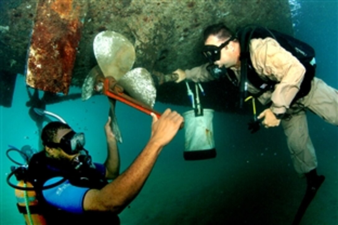 U.S. Navy Senior Chief Billy Gilber watches as a member of the Saint Kitts coast guard replaces the propeller of a small patrol boat in the waters of Zante, Saint Kitts and Nevis, July 24, 2008. The two divers conducted the dive in support of Navy Diver-Global Fleet Station 2008, an exercise to maintain strong multilateral partnerships. 