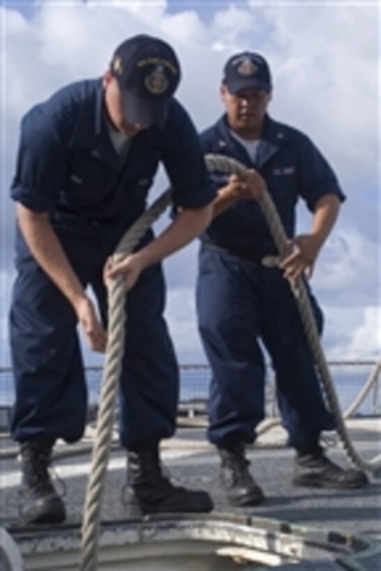 U.S. Navy Seaman Corey Rea (left) and Petty Officer 3rd Class Mark Alejandro stow a mooring line aboard the guided missile destroyer USS John S. McCain (DDG 56) after a refueling stop in Apra Harbor, Guam, on July 22, 2008.  The McCain is one of seven Arleigh Burke-class guided missile destroyers assigned to Destroyer Squadron 15.  