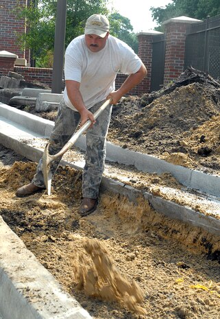Donald Marchant prepares an area for paving by the Dorchester Gate July 30. The construction project to help improve the traffic flow around the gate is estimated to be completed Aug. 24. Mr. Marchant is a contracted foreman with an off-base agency. (U.S. Air Force photo/Airman 1st Class Melissa White)