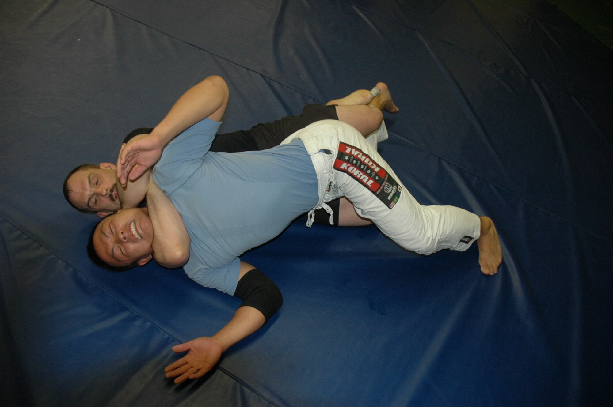 Tech Sgt. Michael Keith, 729th Air Control Squadron satellite and wideband systems, performs a rear-naked choke on Tim Tcha, maintainerfor Sorenco Labs, during a seminar with Gabriel Gonzaga, a UFC competitor, at the Mori Academy of Martial Arts in Sunset, July 26. (U.S. photo by Airman 1st Class Robby Hedrick)