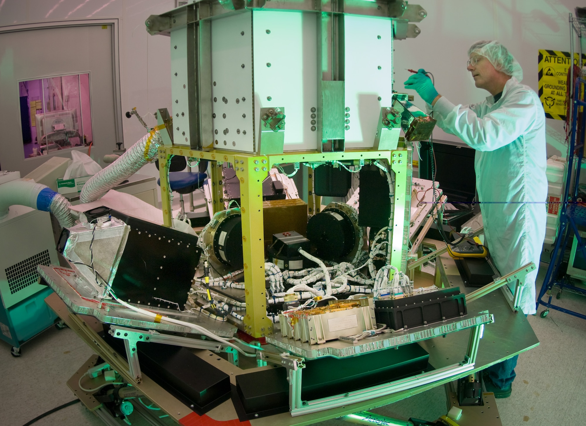 Martin Leahy performs voltage and continuity tests on a tactical satellite, known as Tactical Satellite-3, at the Space Vehicle Directorate at the Air Force Research Laboratory, Kirtland Air Force Base, N.M.  The satellite is scheduled to be launched in October. Mr. Leahy is a field engineer with ATA Aerospace.  (U.S. Air Force photo/Lance Cheung) 