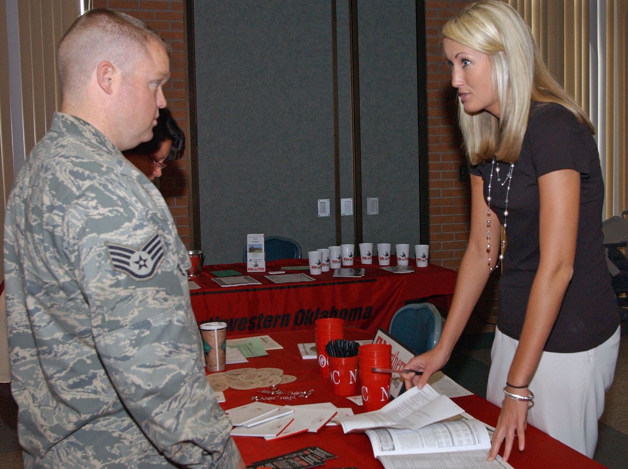 An education fair showcasing 16 colleges was hosted on July 30th here at the Vance Collocated Club. Staff Sgt. Scott Drake, 71st Medical Operations Squadron, receives information about college at Northern Oklahoma College from Jodi Ackerman, Coordinator for High School and College Relations. (U.S. Air Force photo by Stephen M. Fuller)