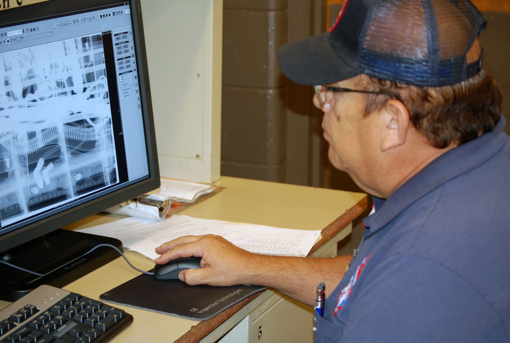 LAUGHLIN AIR FORCE BASE, Texas-- Eloy Ugarte, 47th Maintenance Directorate, reads an X-ray film on the computer to check for disbonding of the flight control surfaces during an inspection process at the Non-Destructive Inspection shop here July 25.  Members of the NDI are responsible for performing inspections on the T-1, T-6, and T-38 aircraft looking primarily for cracks and other degradation factors such as water in the honeycomb, corrosion, or disbonding of the flight control surfaces. (U.S. Air Force photo/Staff Sgt. Olufemi A. Owolabi)