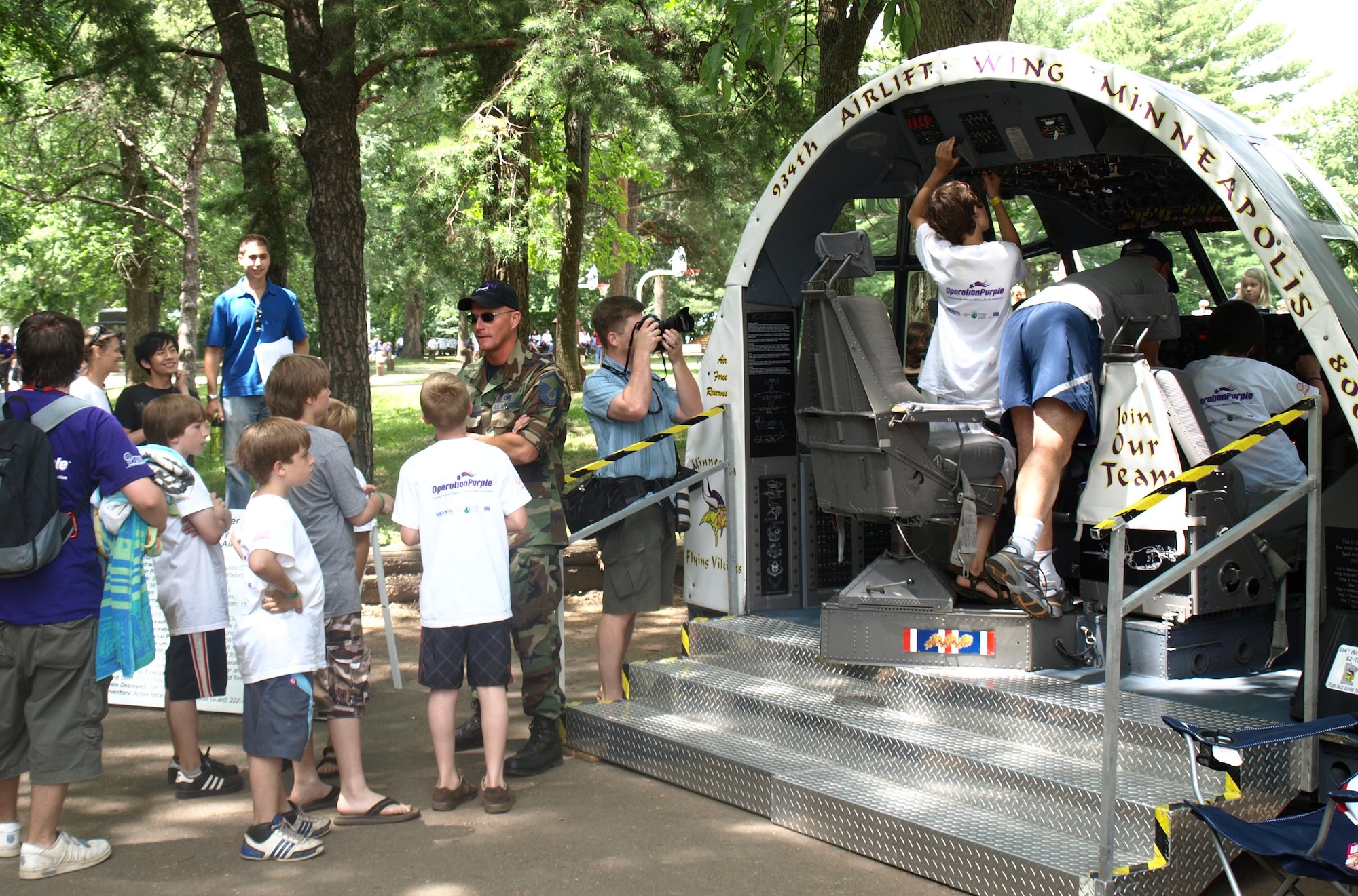 Master Sgt. Eric Johnson talks about the C-130 flightdeck display with children of
deployed military members at an Operation Purple camp in Hudson, Wi s . July 3. (Air Force Photo/Tech. Sgt. David Dudash)         