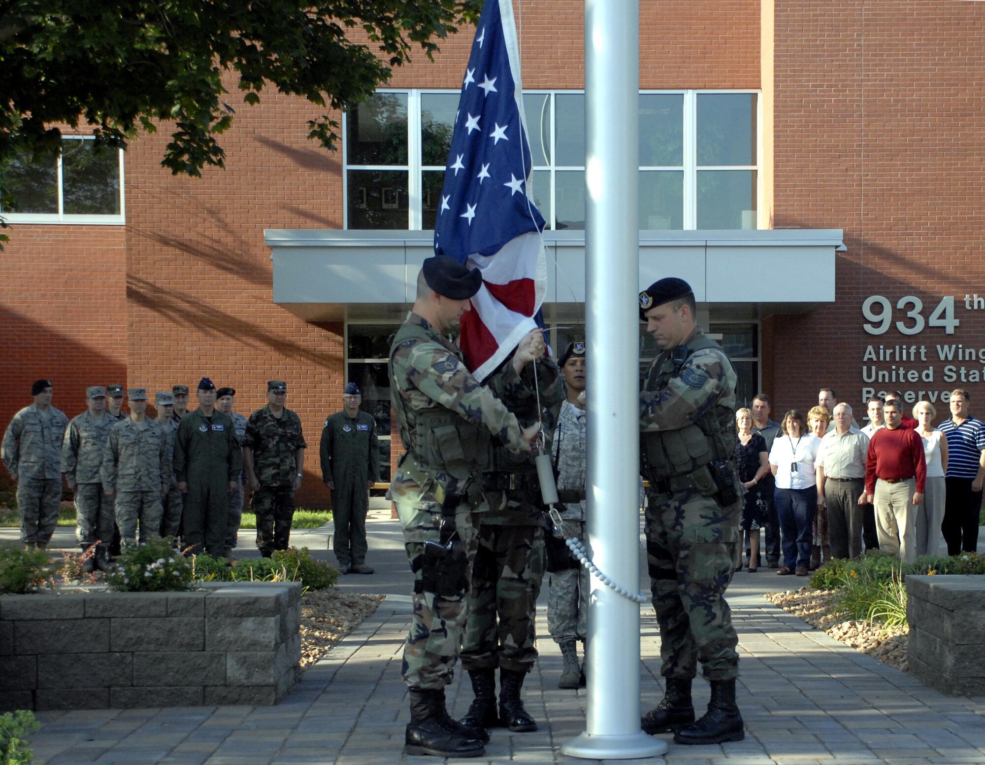 (From left) Staff Sgt. Tim Gassman, Tech Sgt. Kevin Engle, Master Sgt. Nicolette Shegstad and Tech Sgt. Glen Kramlinger, 934th Security Forces Squadron, raise the flag during a morning ceremony dedicating the new plaza area outside the 934th Airlift Wing Headquarters. (Air Force Photo/Master Sgt. Paul Zadach)
