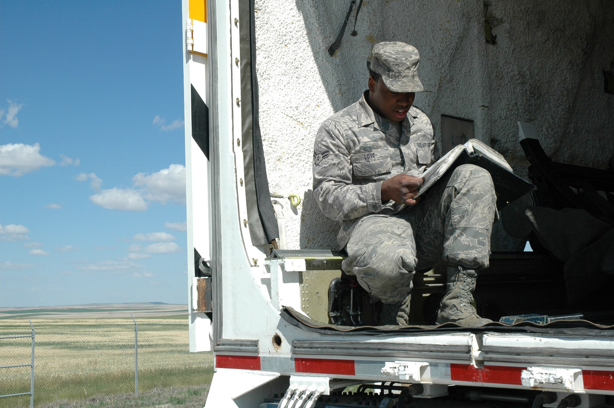 Airman 1st Class Kevin Love, 341st Missile Maintenance Squadron, reads a technical order while inspecting and preparing the inside of the payload transporter before the last component was pulled from the 564th Missile Squadron. The final pull was accomplished July 28 at Tango 41. (U.S. Air Force photo/Airman 1st Class Emerald Ralston)
