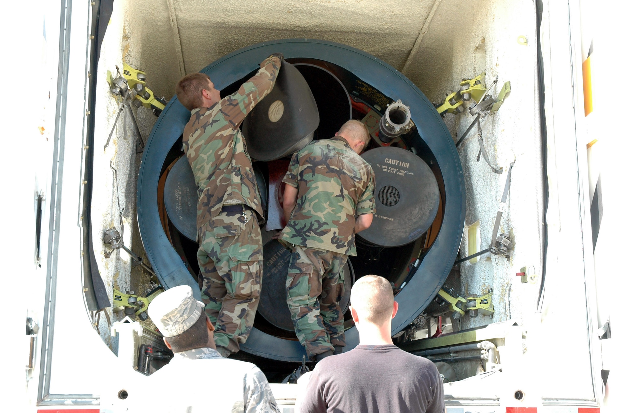 Airmen 1st Class Joshua Holder and Christopher Foster, 341st Missile Maintenance Squadron, secure and cover a weapon system component after extracting it from the silo at Tango 41. This was the final component to be removed from the 564th Missile Squadron. (U.S. Air Force photo/Airman 1st Class Emerald Ralston)
