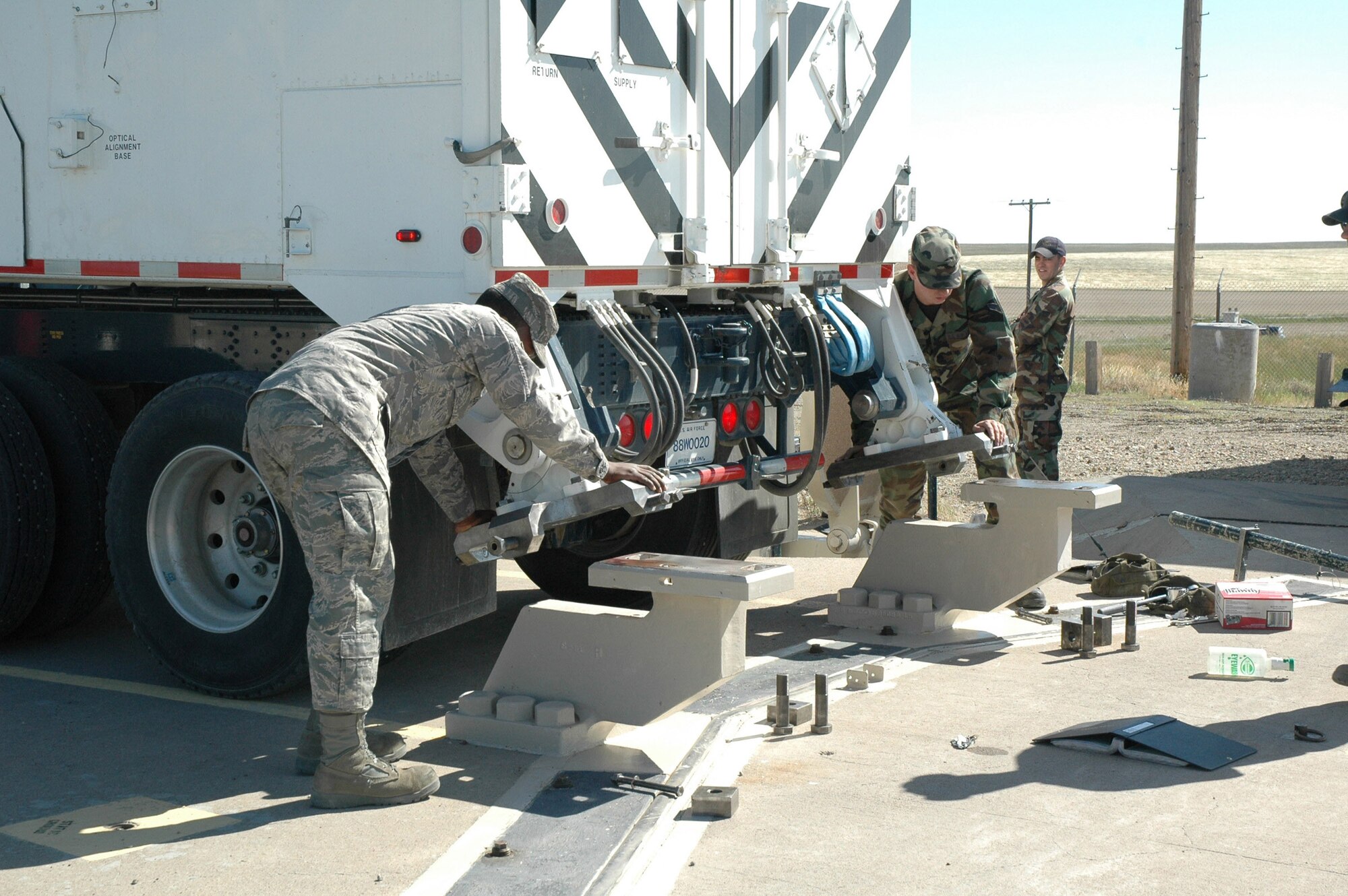 AIrmen 1st Class Kevin Love and James Thompson, 341st Missile Maintenance Squadron, position the transport erector pylon plates onto the launch facility pylons in preparation to extract the final weapon system component from the 564th Missile Squadron July 28. (U.S. Air Force photo/Airman 1st Class Emerald Ralston)