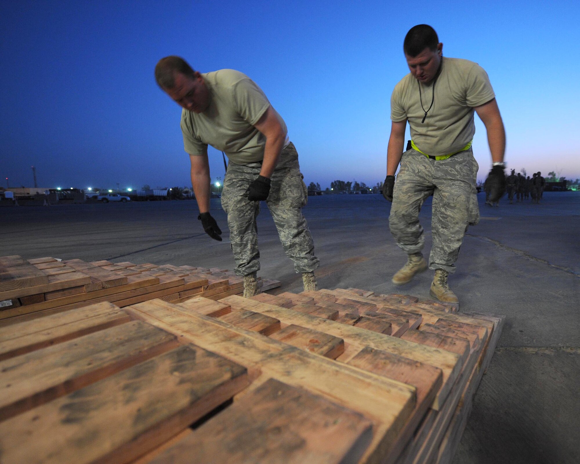 Staff Sergeants Jessy Harper (left) and Jacob McCloud check the placement of special 2,000 pound ramps built to unload new communication units from a C-17 Globemaster III cargo aircraft. Sergeants Harper and McCloud are deployed to the 447th Expeditionary Logistics Readiness Squadron. (U.S. Air Force photo/Master Sgt. Brian Davidson)


