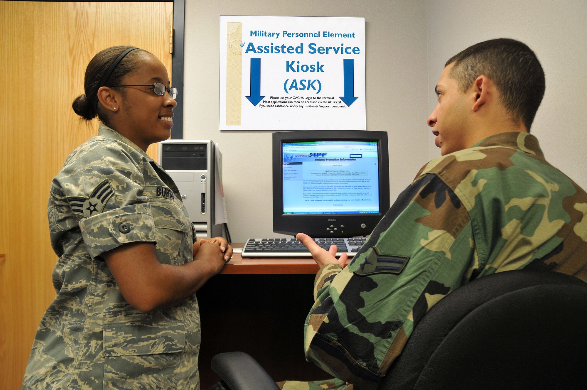 Senior Airman Dorothy Burns assists Airman 1st Class Emmanuel Alba with accessing and updating his vRED (record of emergency data) using the Assistance Service Kiosk. (U.S. Air Force photo/John Turner)