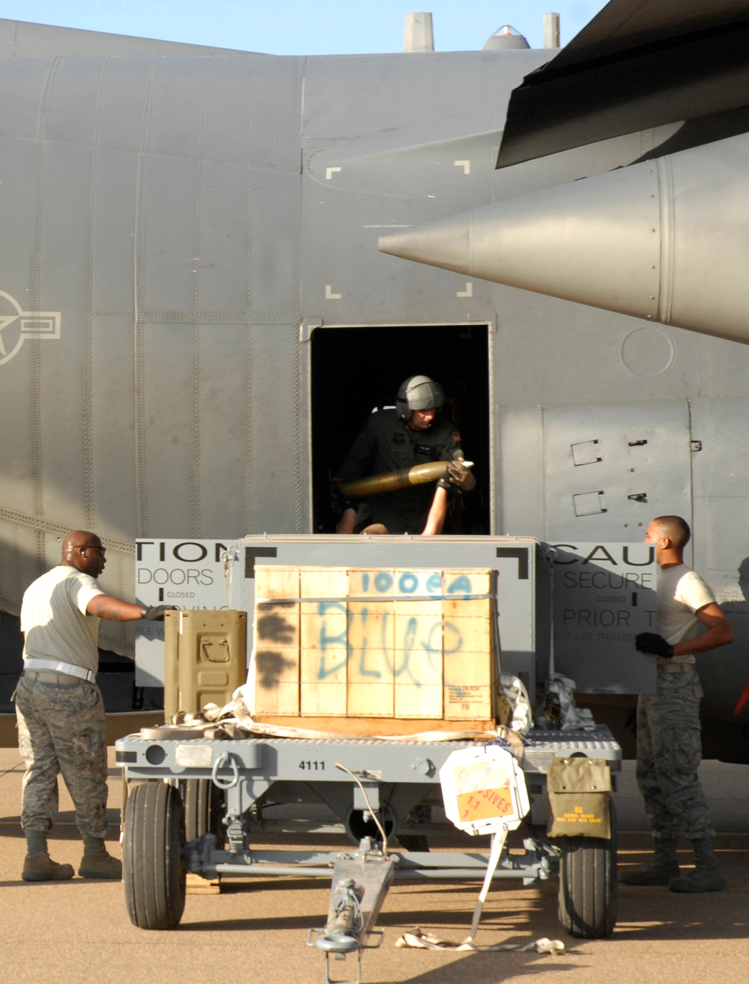 CANNON AIR FORCE BASE, N.M. -- Airmen from the 27th Special Operations Equipment Maintenance Squadron unload munitions and hand them to the crew aboard an AC-130H Spectre Gunship July 26. Airmen assigned to 1st Special Aircraft Maintenance Squadron, Hurlburt Field, Fla., were here to train and refine local flying procedures for their eventual move to Cannon as members of the 16th Special Operations Squadron.  (U.S. Air Force photo/Senior Airman Liliana Moreno)