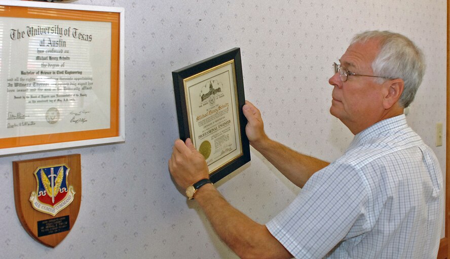 DYESS AIR FORCE BASE, Texas -- Mr. Michael Schultz, deputy base engineer, takes a picture off  the wall as he packs up his office here July 30.  After 33 years of service, Mr. Schultz is planning to retire Aug. 1.  He has been one of the cornerstones of the 7th Civil Engineer Squadron for more than 20 years of his federal career.  (U.S. Air Force photo by Senior Airman Felicia Juenke)