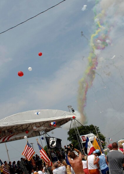 LE CLAIRE, Iowa - A crowd of cyclists cheer for members of the Air Force Cycling Team while fireworks go off during the closing ceremony of the 36th Registers Annual Great Bike Ride Across Iowa, July 26. This is the first closing ceremony for the RAGBRAI in years, and as first time hosts of the RAGBRAI, the natives of Le Claire chose to celebrate with a military appreciation closing ceremony. (U.S. Air Force photo by Airman 1st Class Joanna M. Kresge)