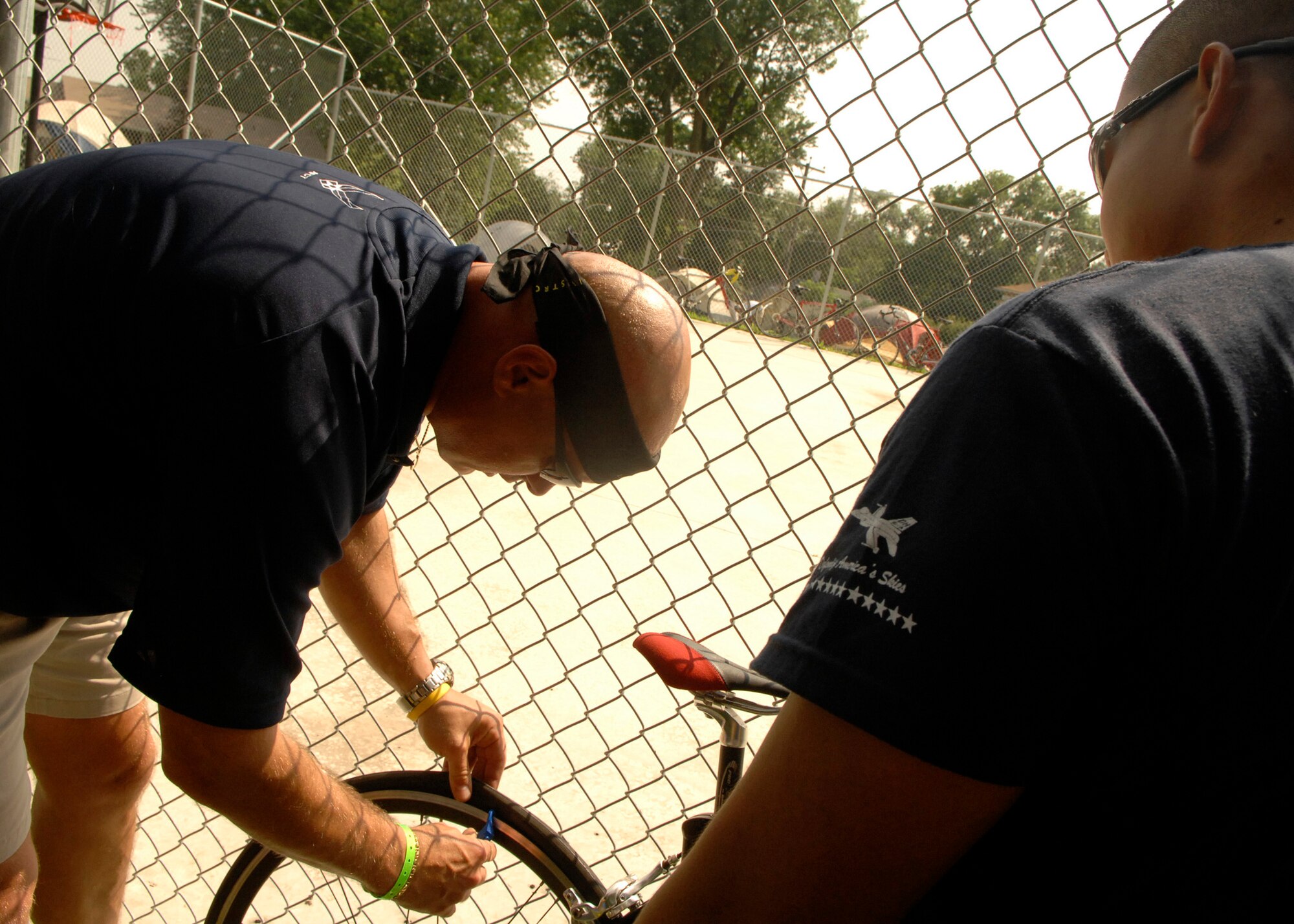 MISSOURI VALLEY, Iowa - Major John Pugh instructs 1st Lieutenant Jose Cadelina how to remove a tire tube during the Registers Annual Great Bike Ride Across Iowa beginning in Missouri Valley, Iowa, on July 19. Members of the Air Force Cycling Team participate in the event annually to recruit in the state of Iowa, as well as staying fit to fight. (U.S. Air Force photo by Airman 1st Class Joanna M. Kresge) 