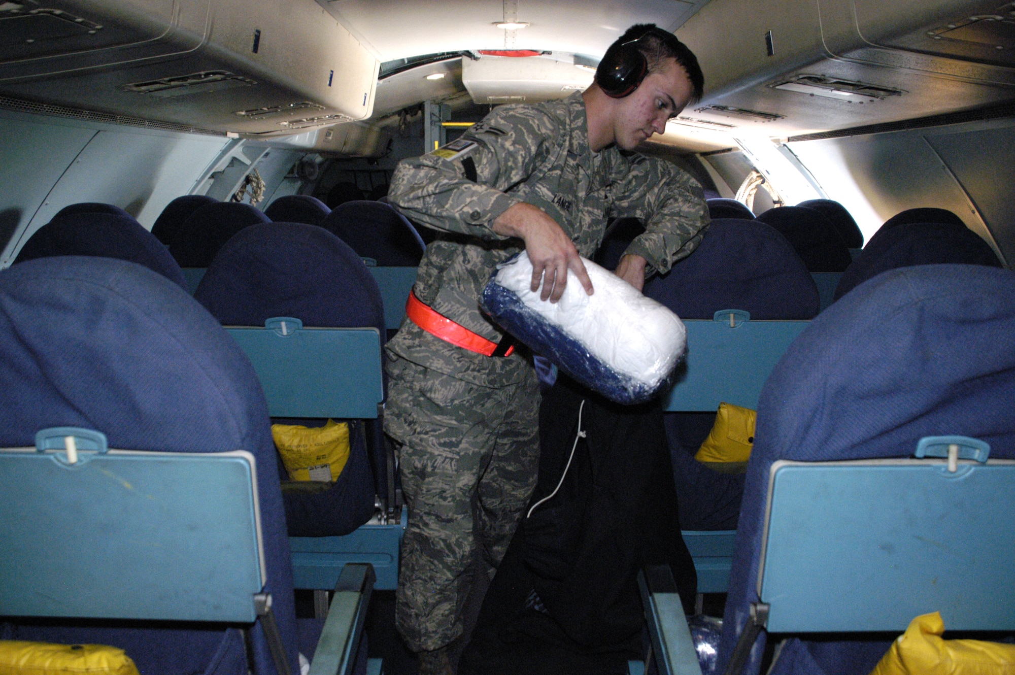 DOVER AIR FORCE BASE, Del. -- Airman 1st Class Ian Lange, 436th Aerial Port Squadron fleet services, supplies each passenger seat with a pillow and blanket. Like invisible flight attendants, fleet Airmen replenish comfort items such as pillows, blankets and meals, and clean the interior of aircraft.  (U.S. Air Force photo/Airman 1st Class Shen-Chia Chu)