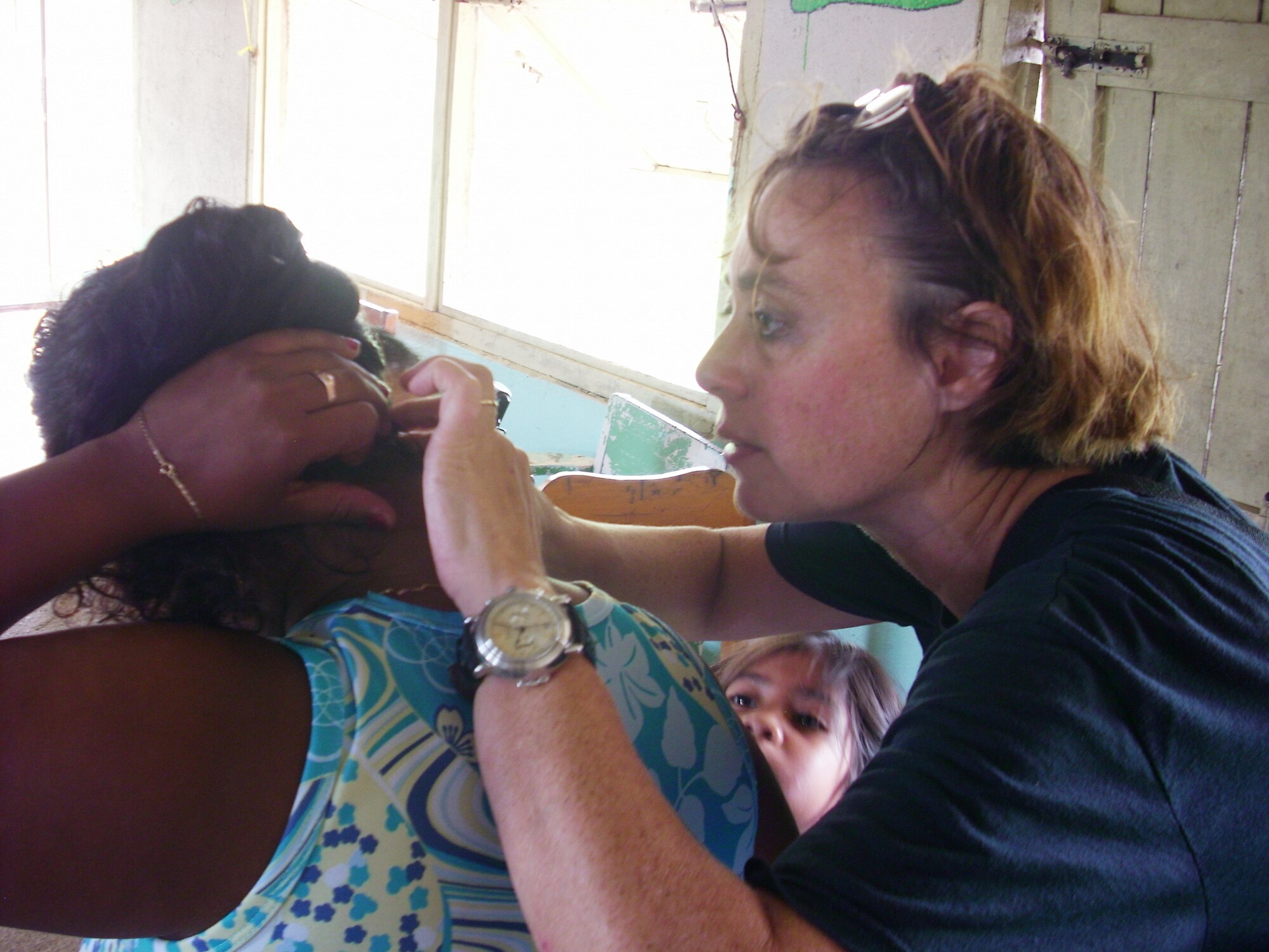 Colonel Elmer examines a patient’s scalp during the medical readiness exercise in Belize.  (Courtesy photo)