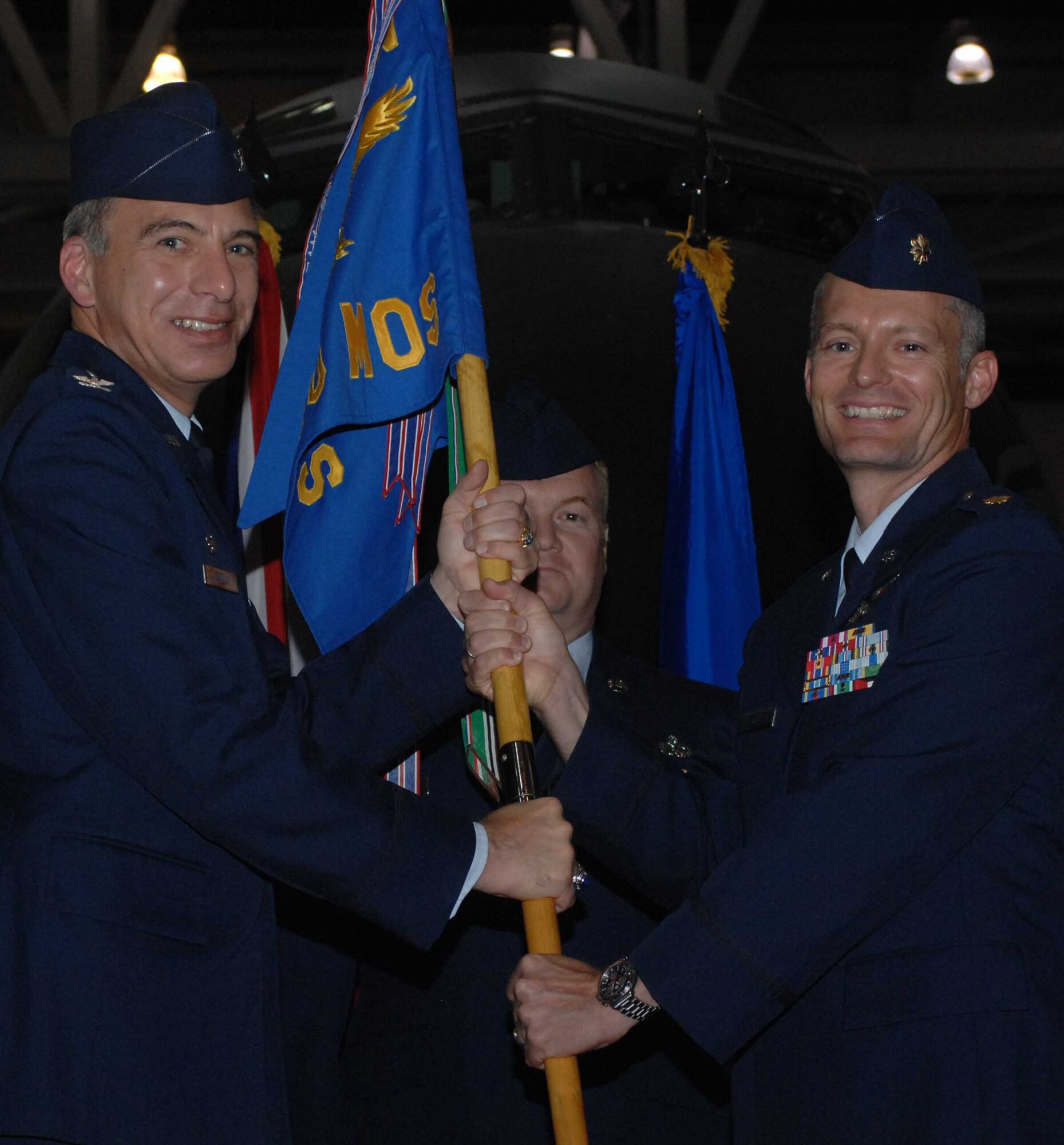 RAF MILDENHALL, England -- Col. Michael Saville, 100th Maintenance Group Commander, hands the 100th Maintenance Operations Squadron guide-on to Maj. Reggie Christianson July 25.  Major Christianson assumes command of the squadron from Maj. Artemis Thomas. (U.S. Air Force photo by Airman 1st Class Brad Smith)