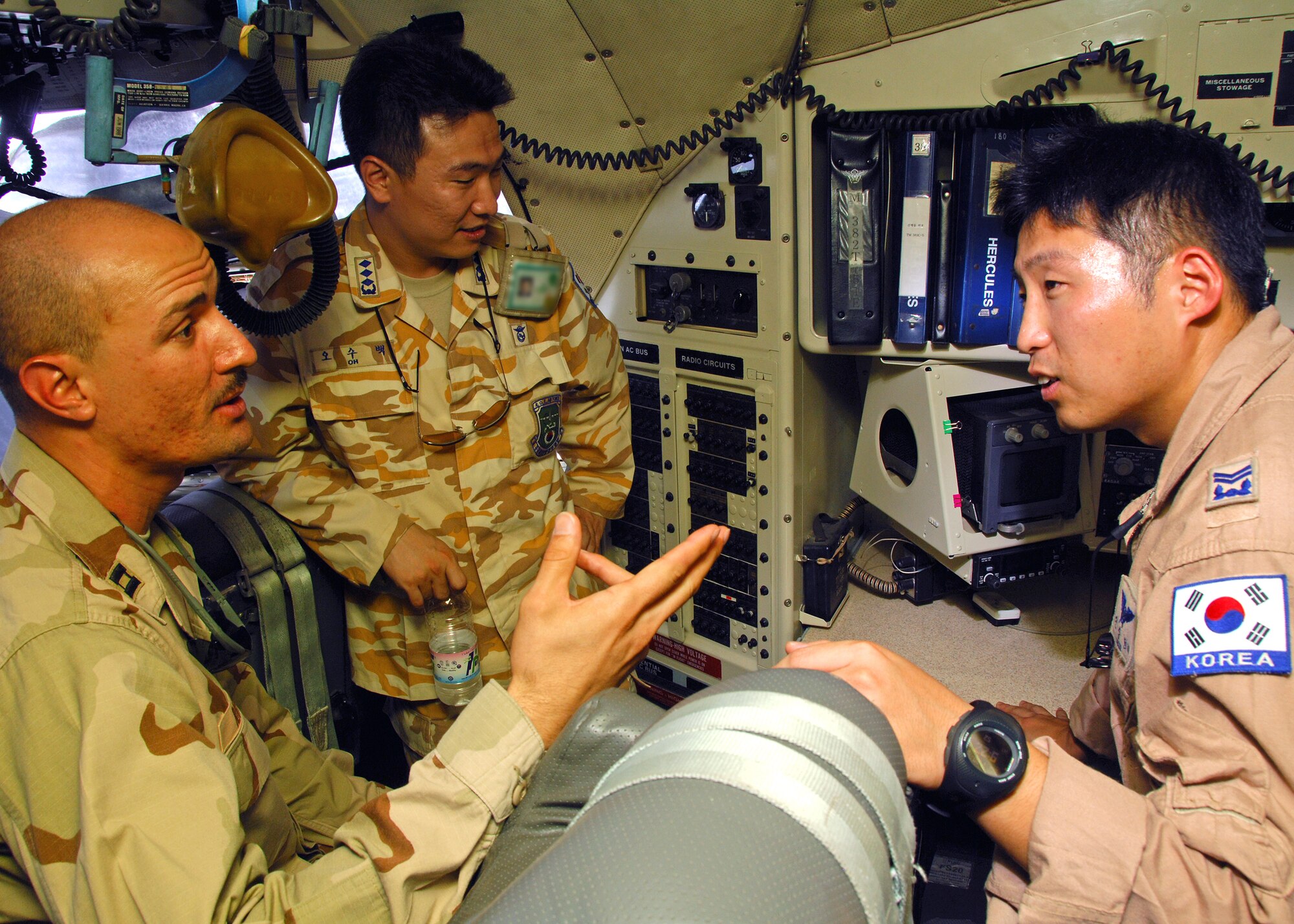 SOUTHWEST ASIA -- Capt. Hector Rivera, assigned to the 386th Expeditionary Maintenance Group, and Republic of Korea Air Force Master Sgt. Jeon discuss the similarities between American and Korean C-130 aircraft on Jul 30 at a base in Southwest Asia. The 386th Expeditionary Maintenance Group toured a ROKAF C-130 as part of a maintenance exchange program between the two units. The program helps facilitate the exchange of ideas and techniques on maintenance service to the aircraft. (U.S. Air Force photo/Tech. Sgt. Raheem Moore)