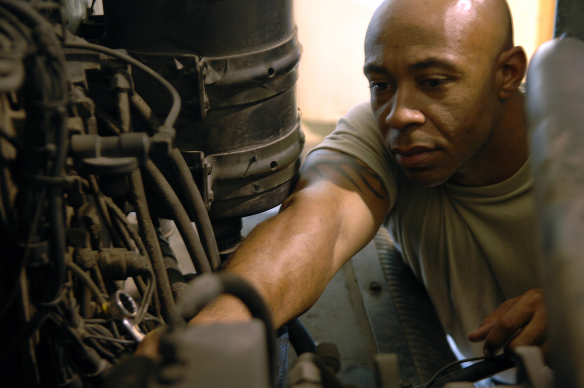 MANAS AIR BASE, KYRGYZ REPUBLIC -- Staff Sgt. Cedric Evans, 376th Air Expeditionary Wing Vehicle Maintenance mechanic, tightens a clamp on the motor of a R-11 fueler. The special purpose maintaner, deployed from Vandenburg Air Force Base, Calif., has worked on the R-11 for nearly a week repairing the transmissions torque converter, returning the vehicle to operational status. (Air Force photo / Tech. Sgt. Michael Voss)