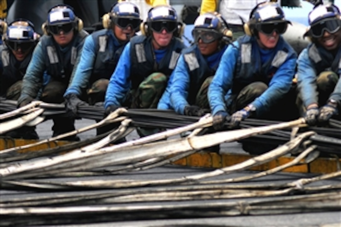 U.S. Navy sailors raise an aircraft barricade aboard USS Kitty Hawk during flight deck drills while under way in the Pacific Ocean, July 23, 2008. The USS Kitty Hawk  is participating in Rim of the Pacific 2008, a biennial international exercise. 