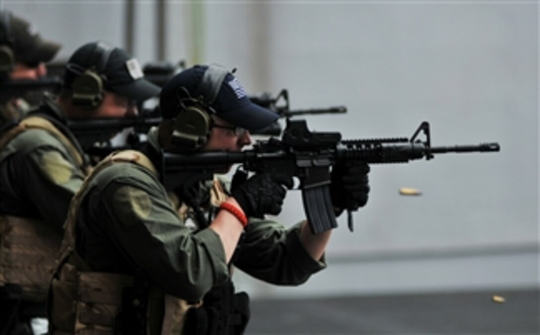 U.S. Navy Petty Officer 2nd Class Jayson Wazny and other sailors with Helicopter Visit Board Search and Seizure Team 2 fire M-4 rifles during a live-fire transition exercise on an elevator aboard the aircraft carrier USS Abraham Lincoln (CVN 72) while underway in the Arabian Sea on July 27, 2008.  The Lincoln is deployed to the U.S. 5th Fleet area of operations in support of maritime security operations.  